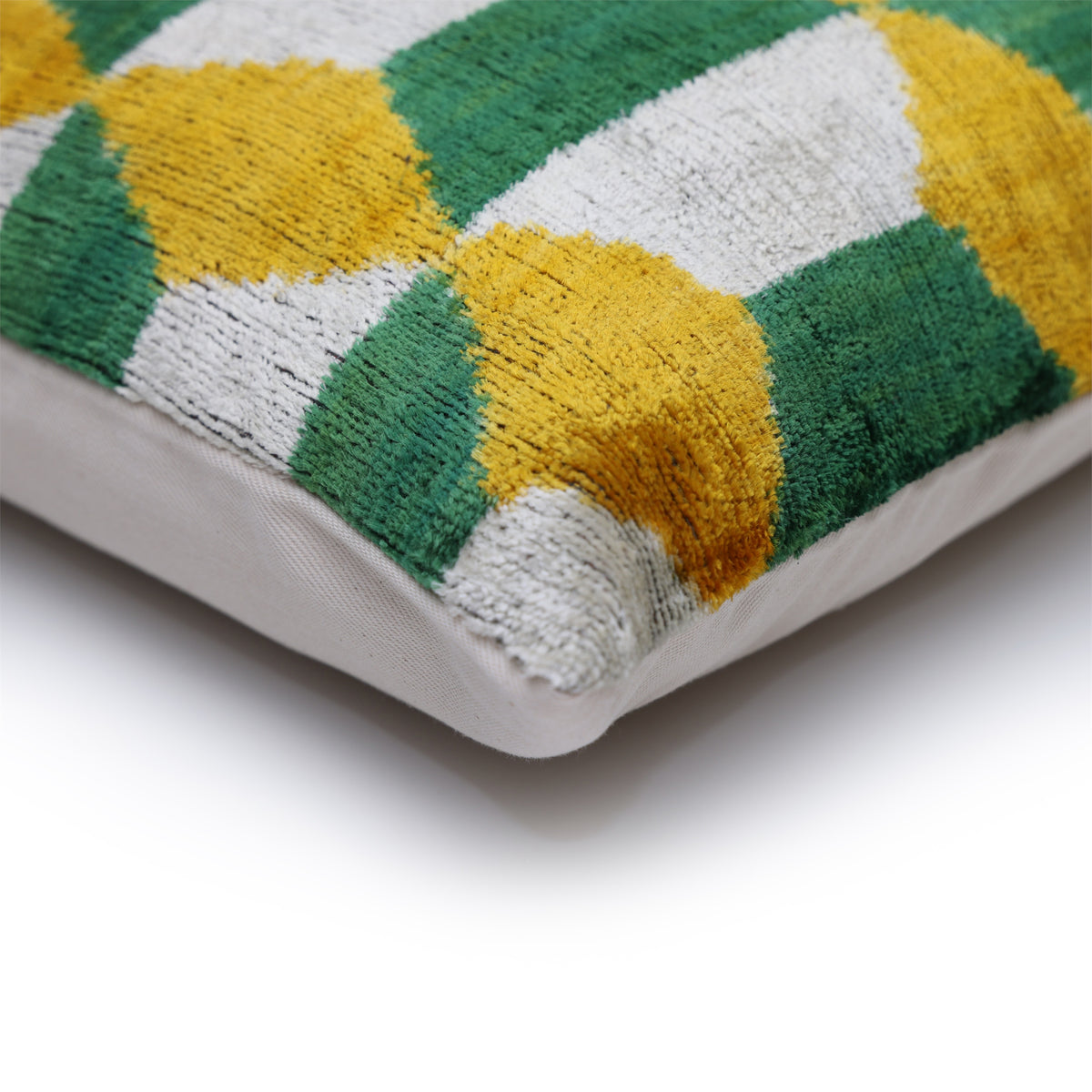 Corner view of geometric velvet front with plain linen backing