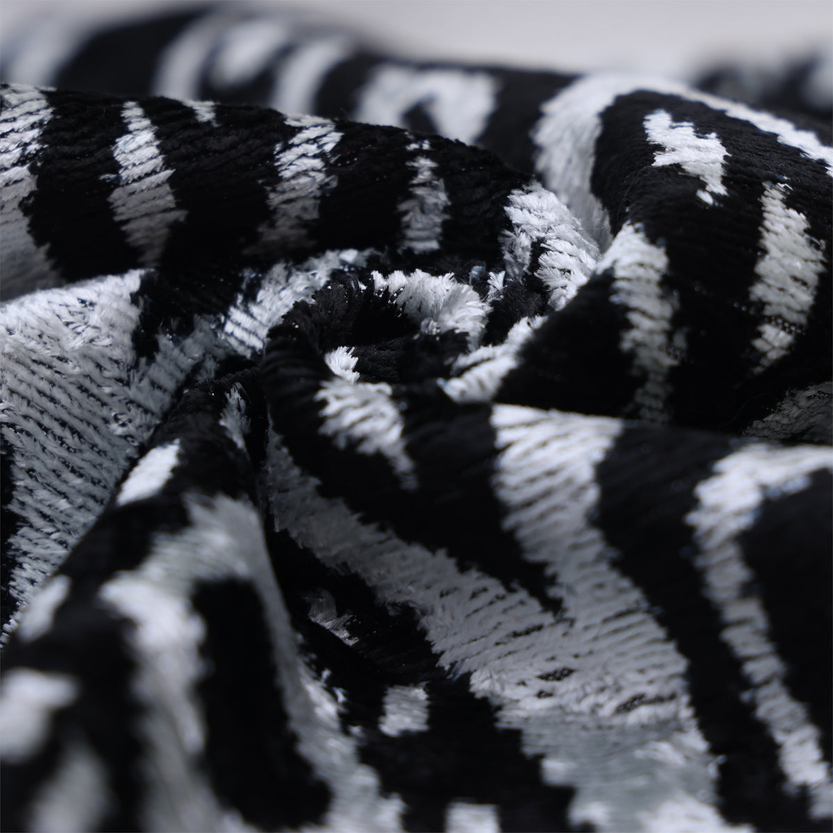 Macro view of silvery white and jet black velvet folded into pleats