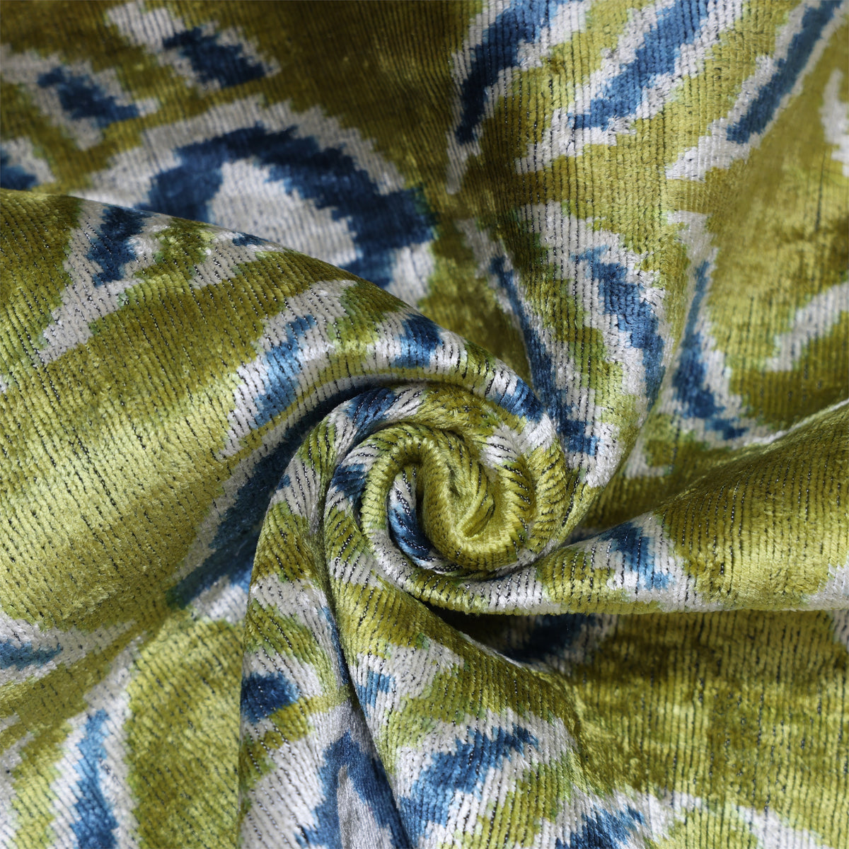 Overhead spiral-folded fabric showing sheen across the olive chartreuse green pattern
