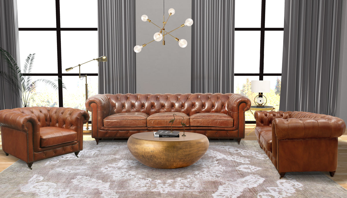A living room with a brown leather Chesterfield sofa and a matching armchair