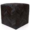 Black cube-shaped ottoman with a chevron pattern on a white background