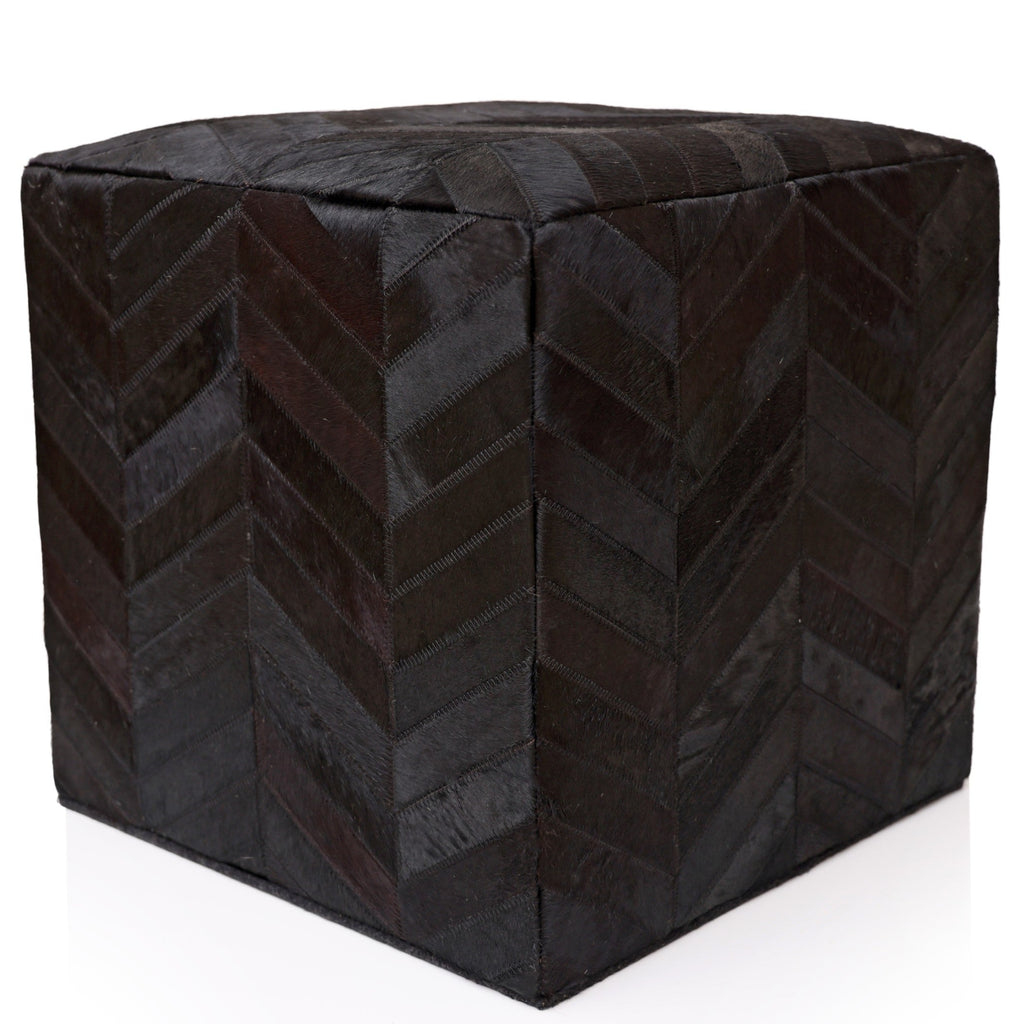 Black cube-shaped ottoman with a chevron pattern on a white background
