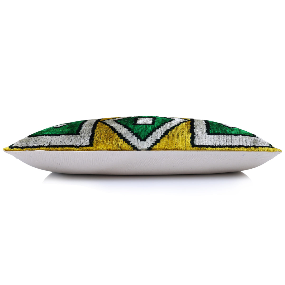 Side profile of the lumbar pillow with its geometric velvet front and plain light back
