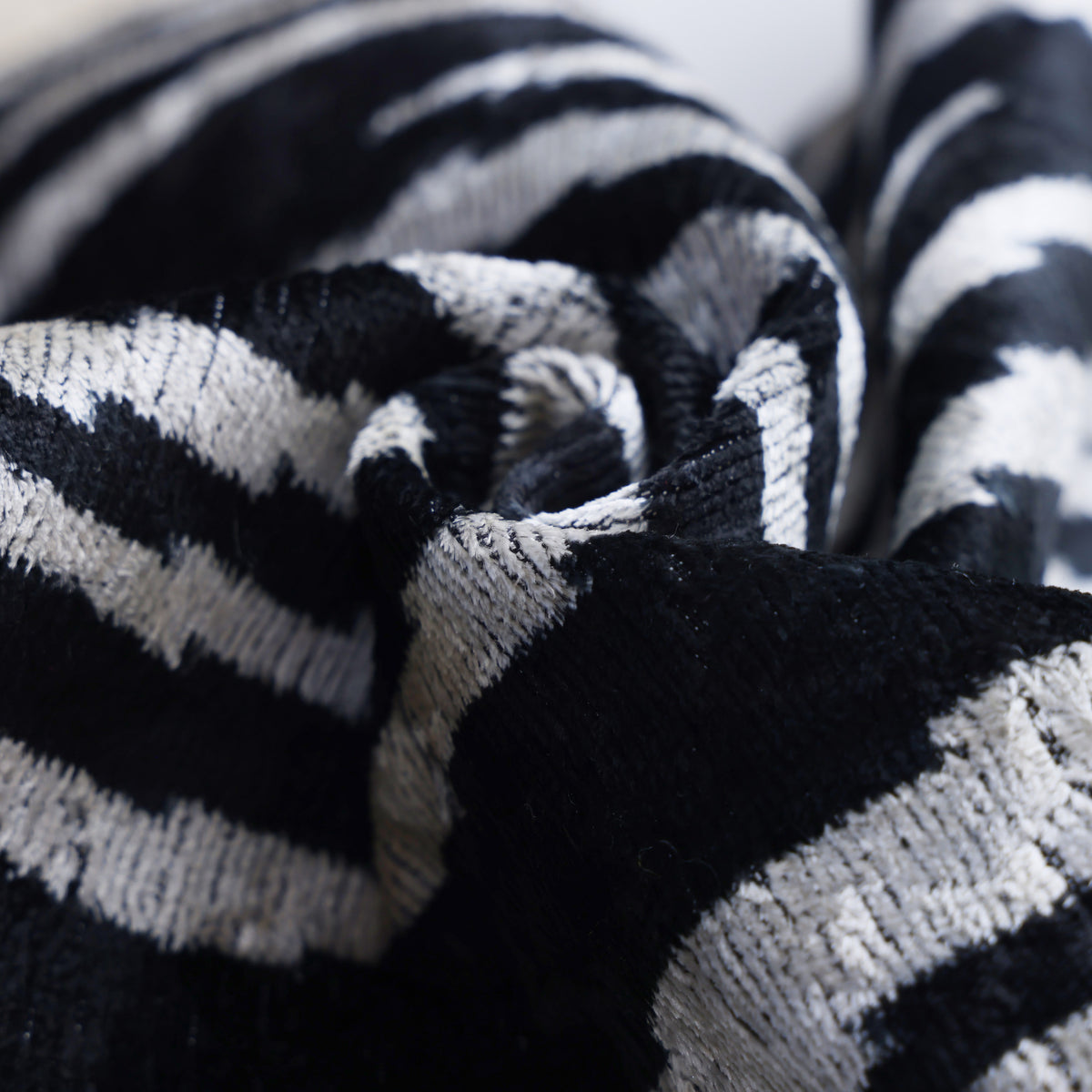 Angled folded silk velvet showing fluid zebra pattern in black and ivory