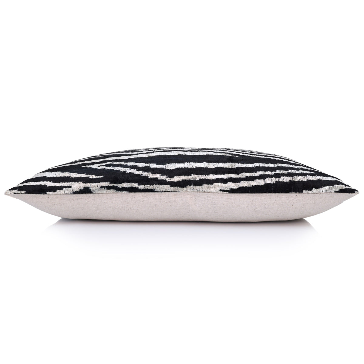 Side profile of the rectangular lumbar pillow with black and ivory velvet face