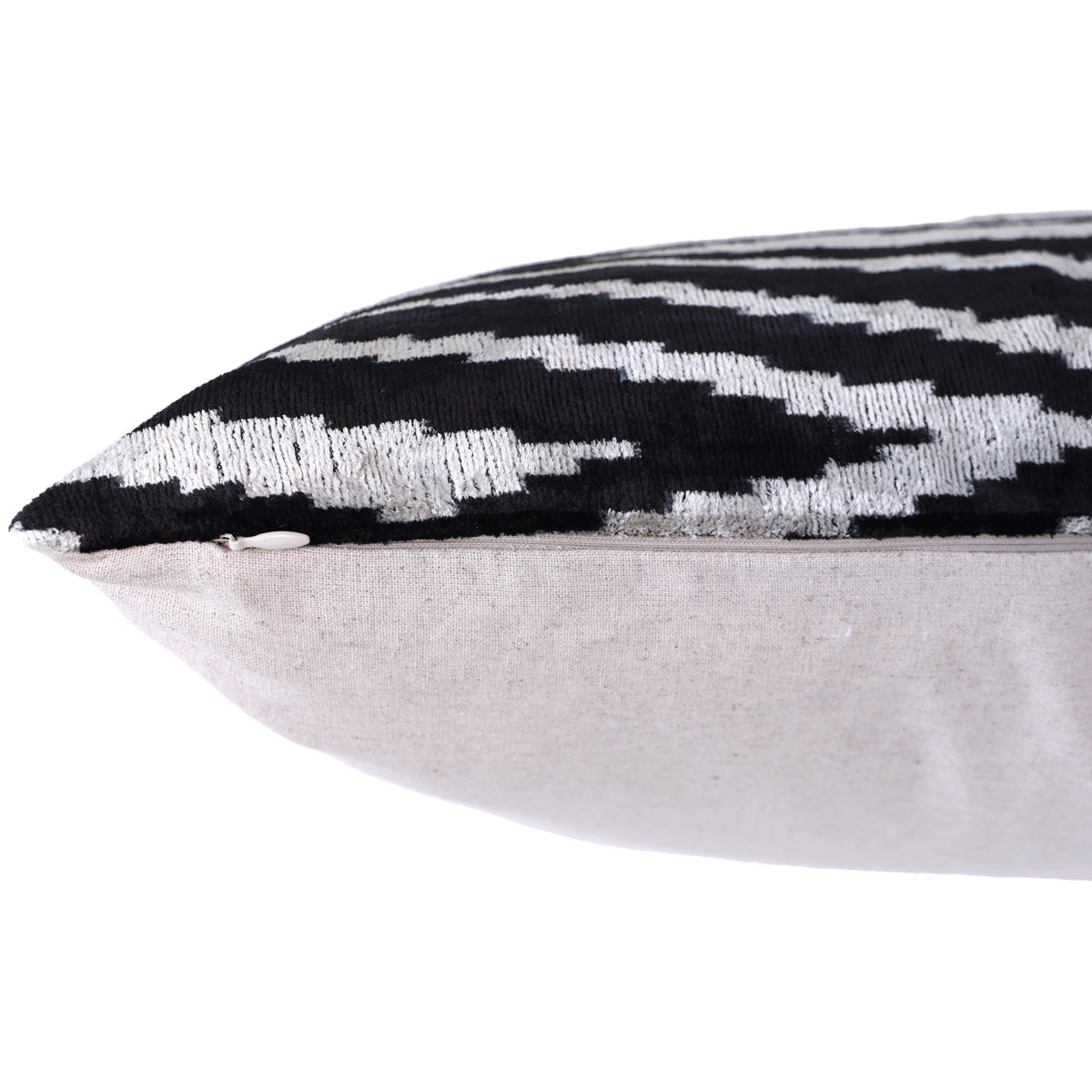 Close-up of the edge seam and hidden zipper on an inky black and ivory velvet pillow