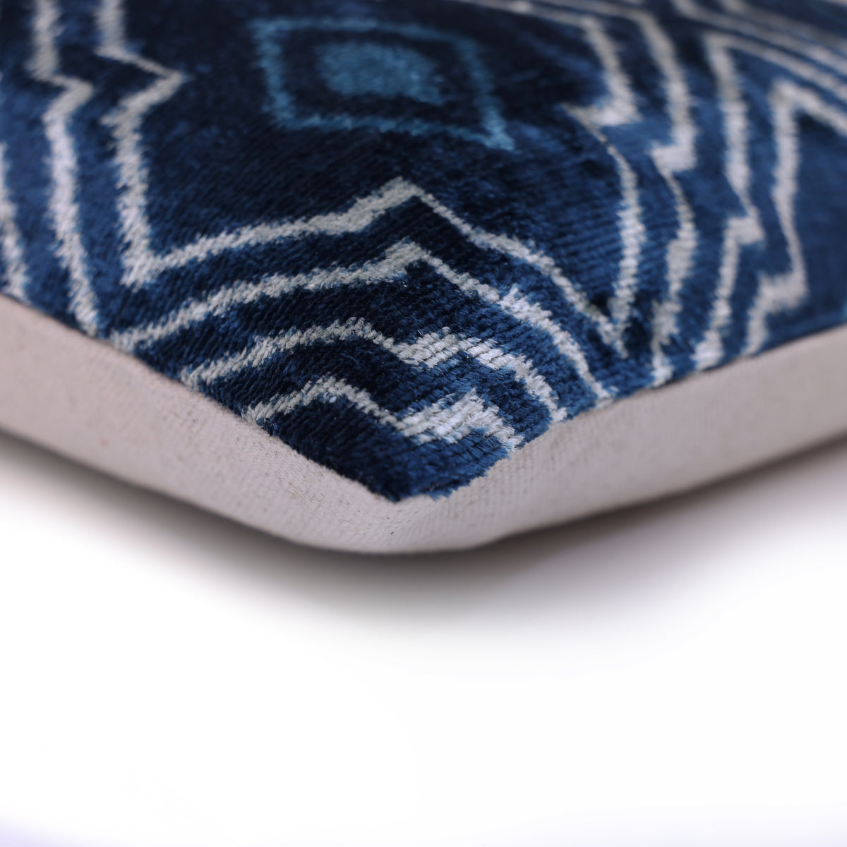 Pillow corner showing blue velvet front joined to white linen backing
