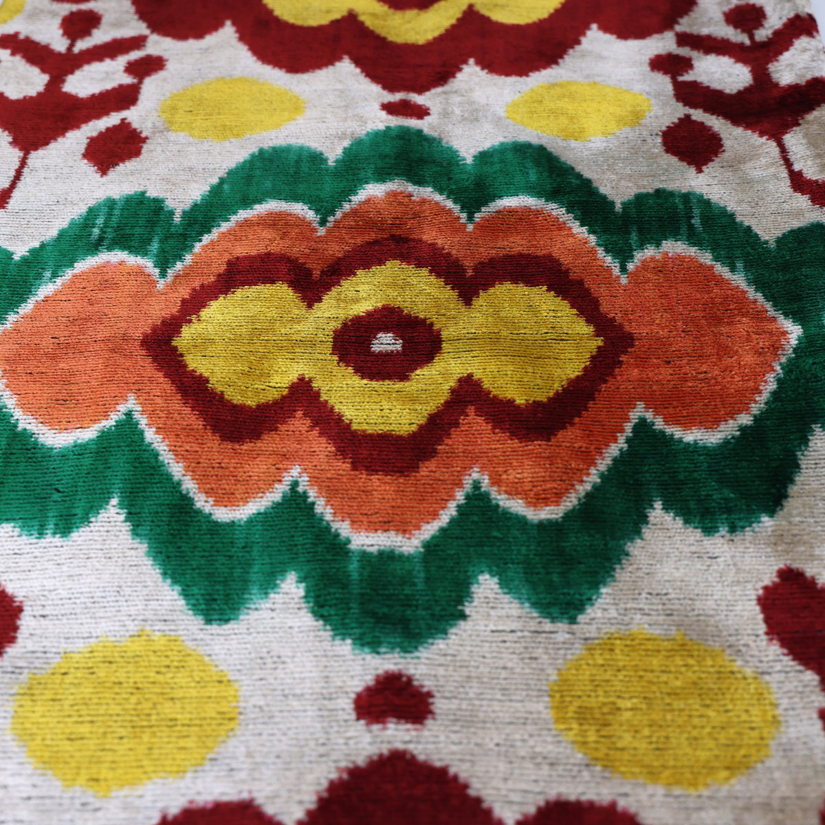 Central ikat medallion with emerald green, terracotta orange and bright yellow details