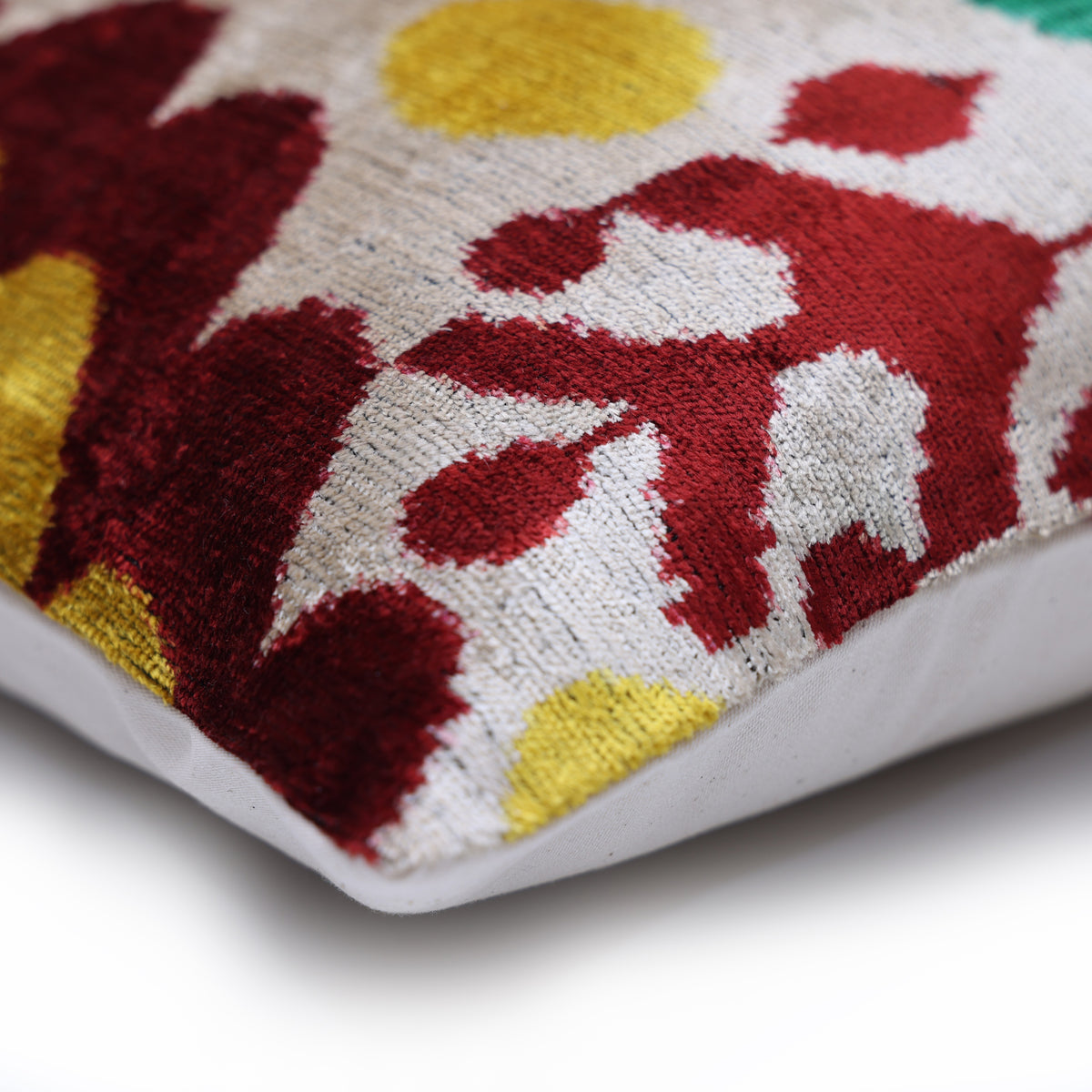 Corner detail of ikat lumbar pillow showing seam and lustrous velvet pile