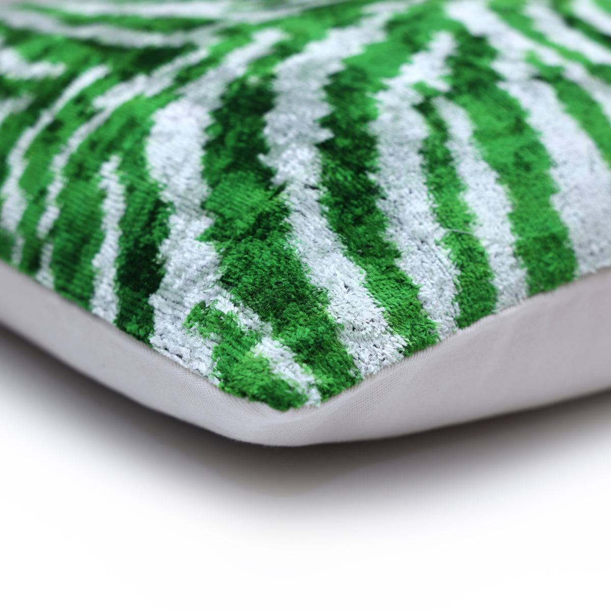 Corner detail of emerald green and cool white zebra velvet with linen backing seam.