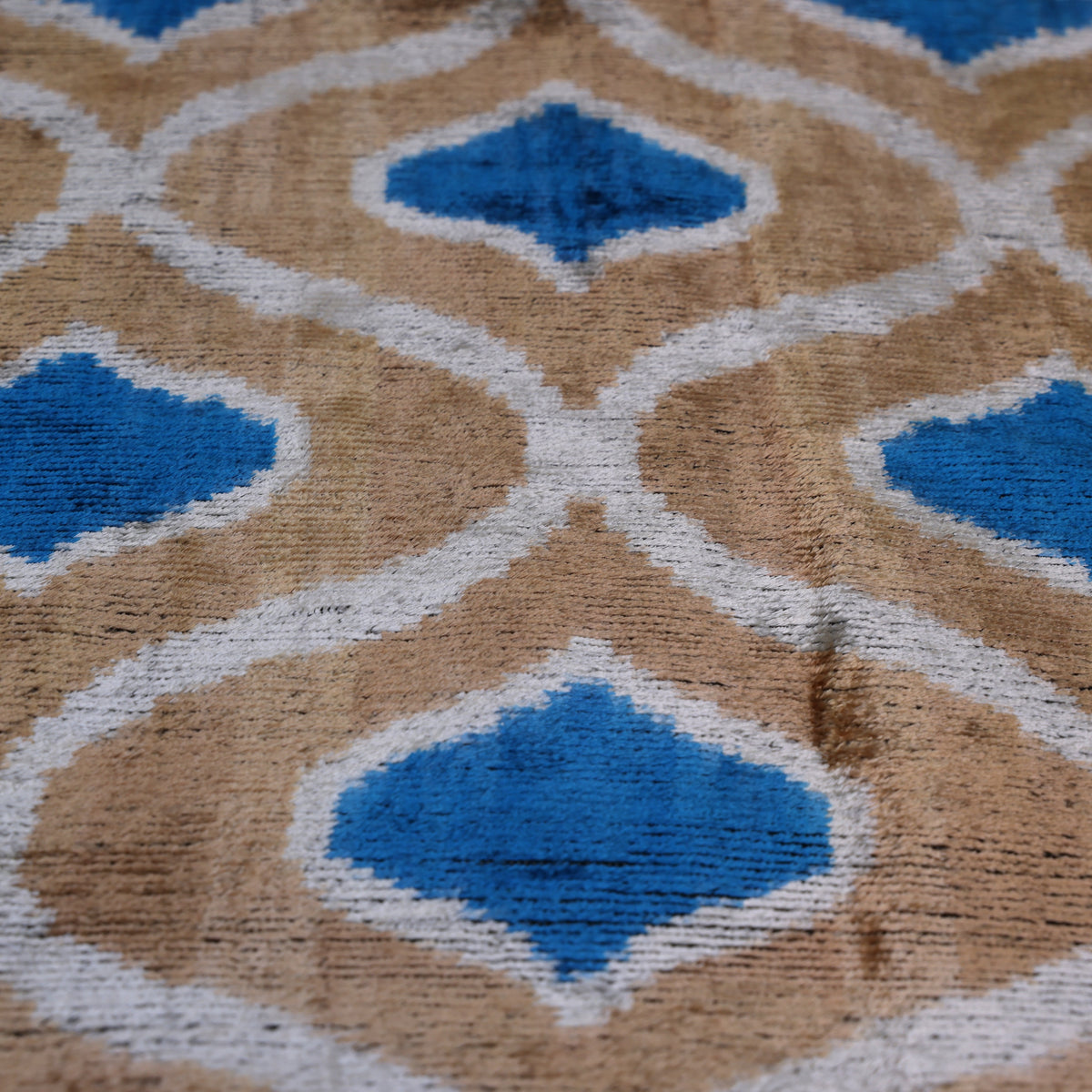 Silvery white and cerulean blue ikat lattice on golden taupe velvet