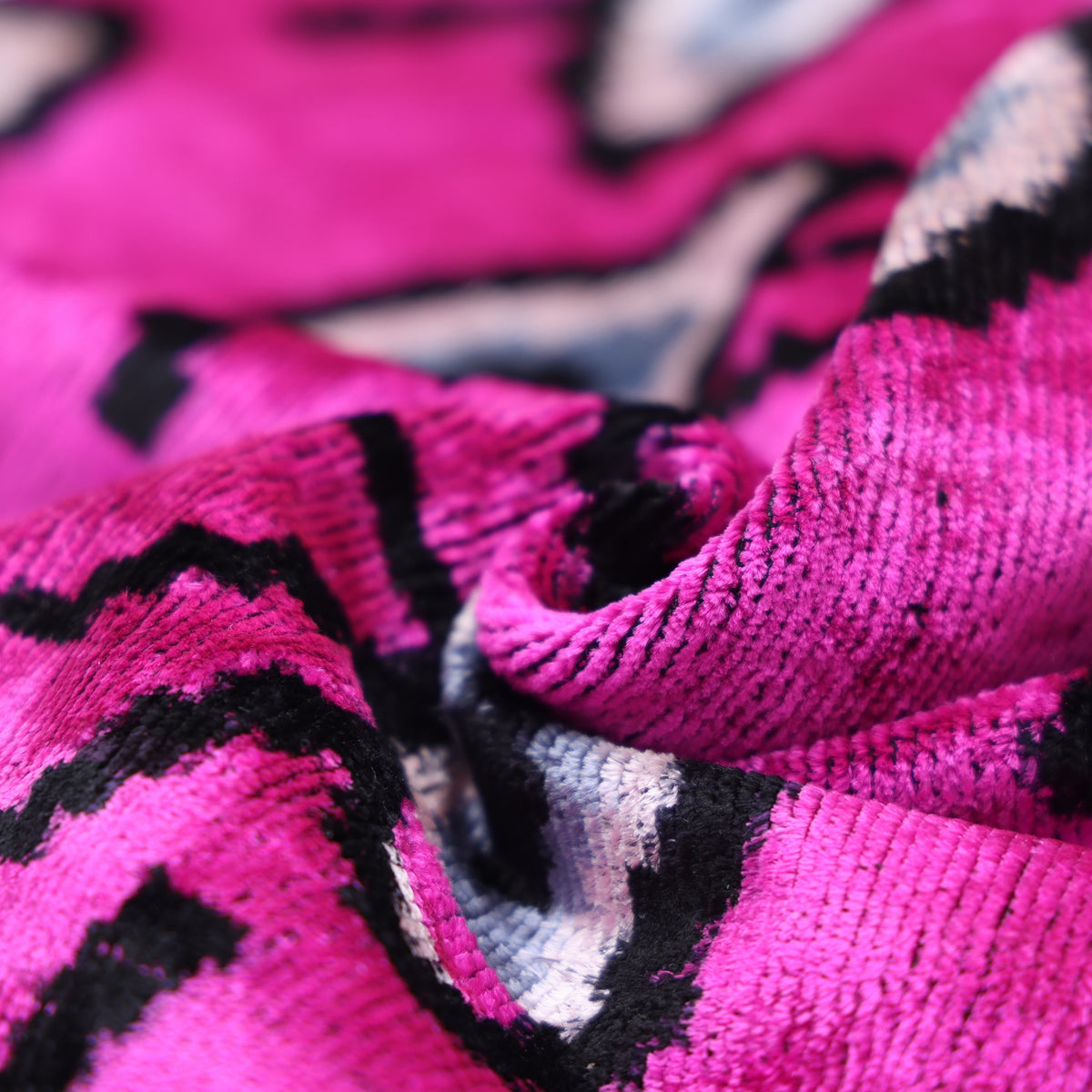 Folded magenta pink velvet pile showing the plush ribbed texture
