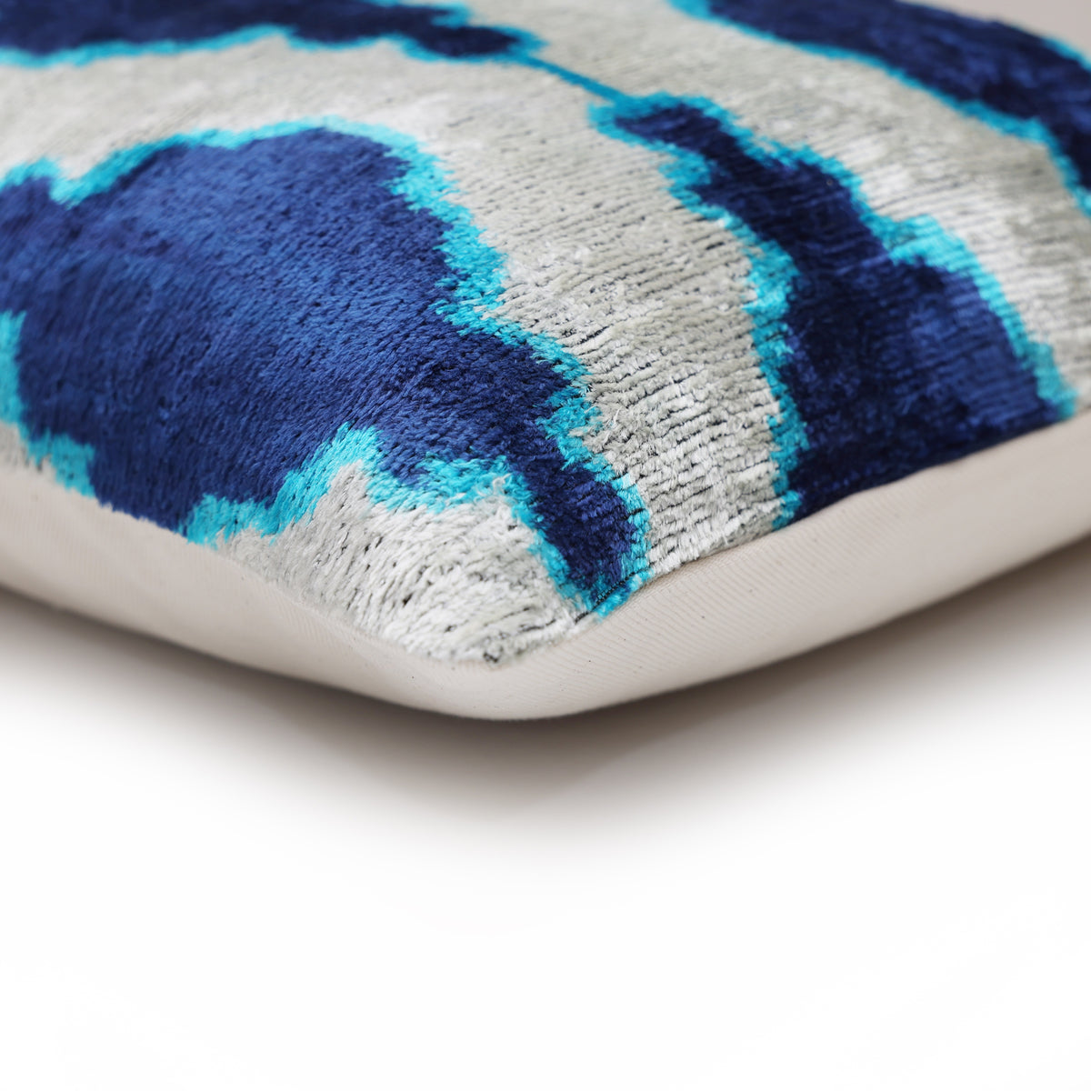 Lumbar pillow corner where patterned silk velvet front meets the plain linen backing