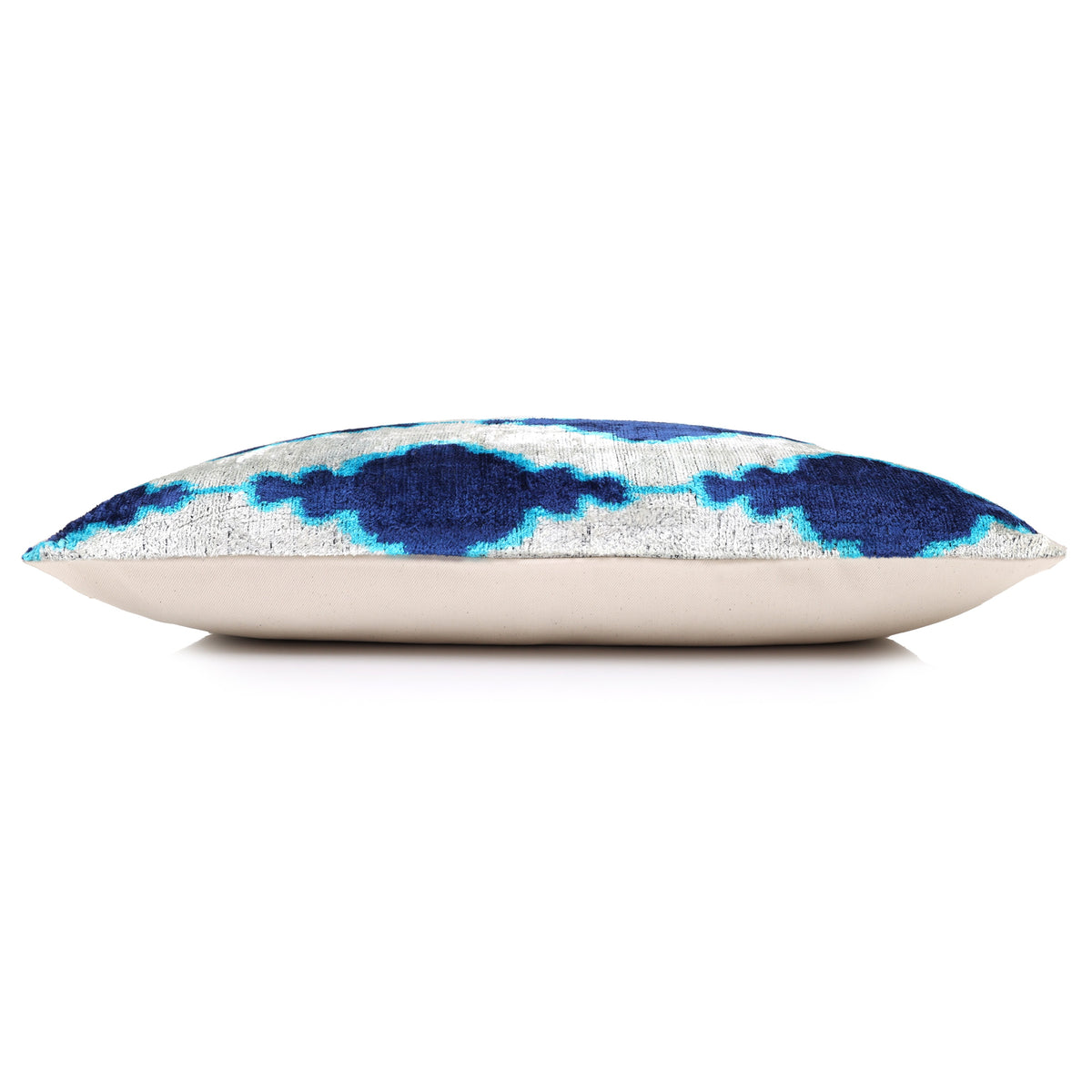 Side profile of the silvery white and blue ikat lumbar pillow with light backing