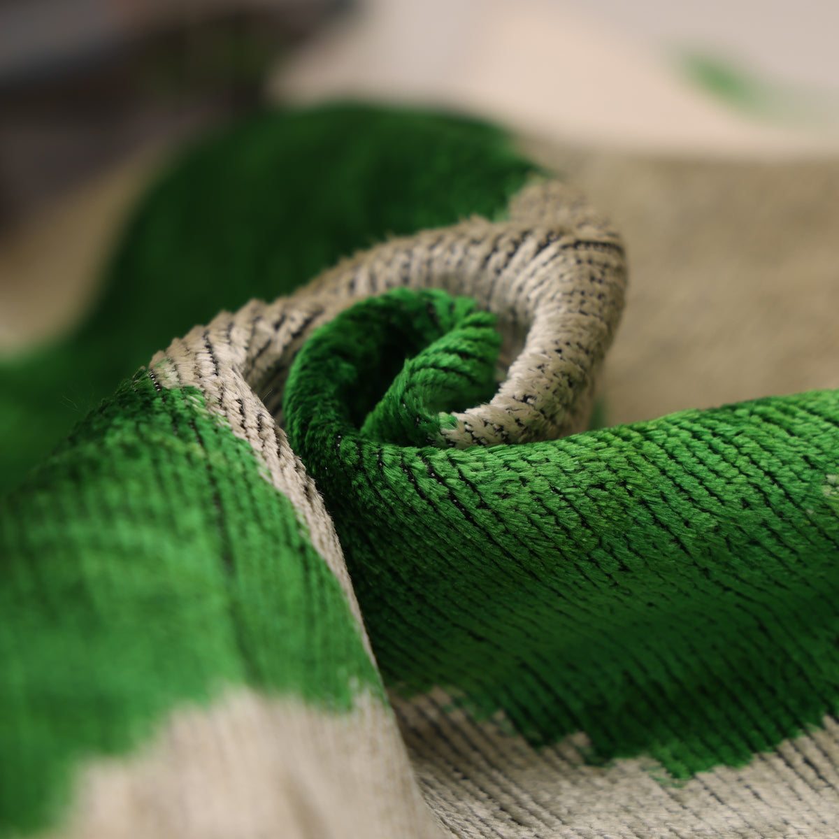 Rolled fabric edge showing the depth of emerald green cut velvet pile