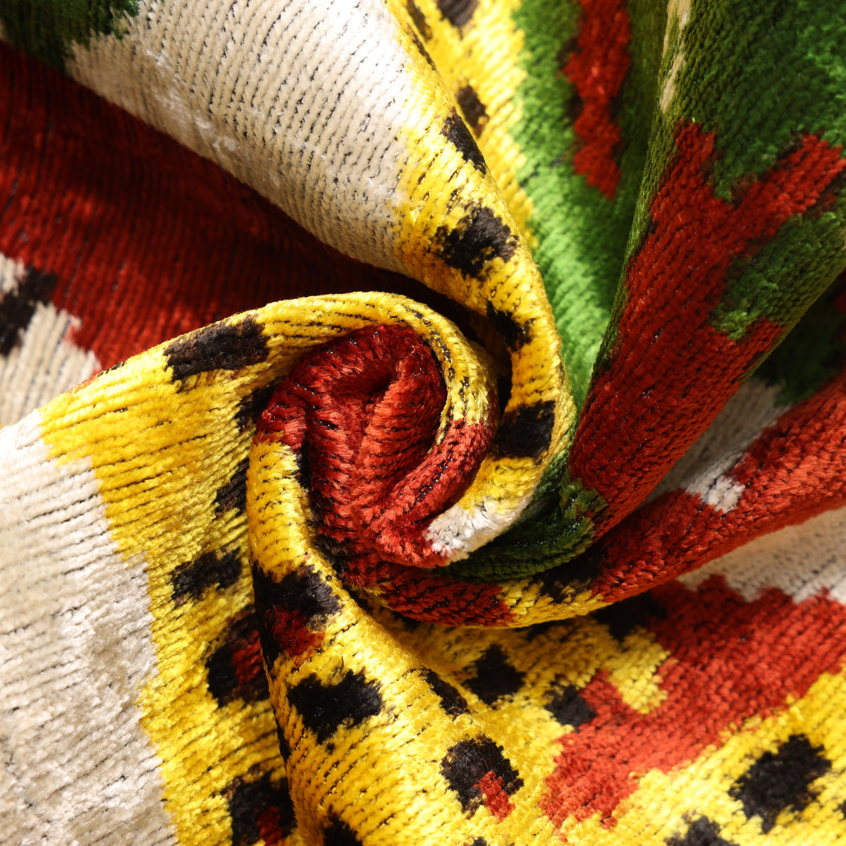 Overhead close-up showing silk velvet pile sheen and multicolor weave