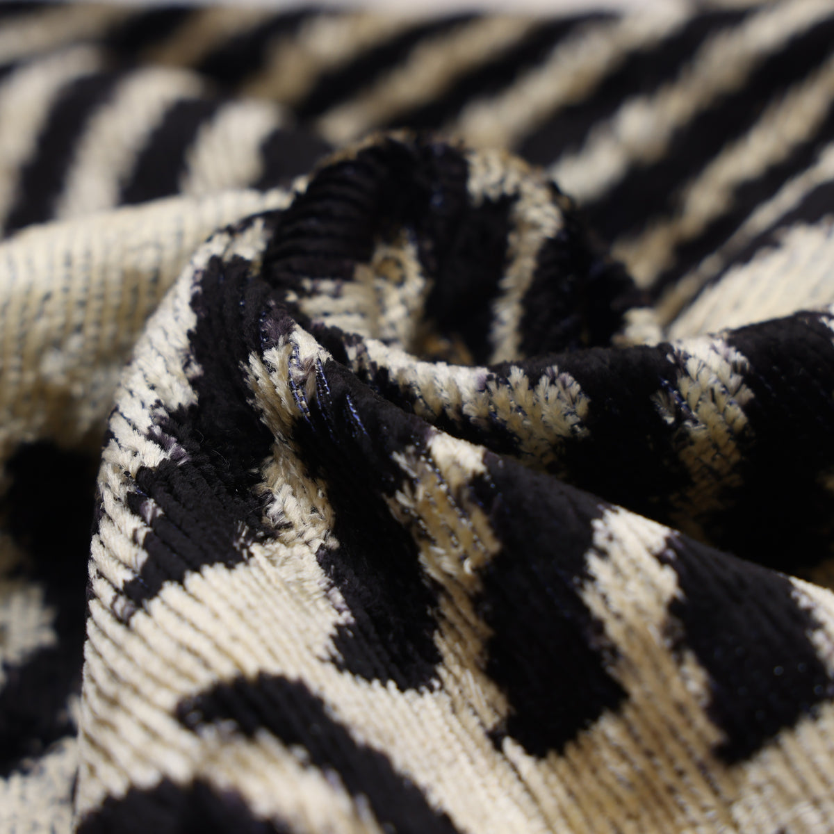 Macro view of cut velvet pile and woven ground in jet black and champagne beige