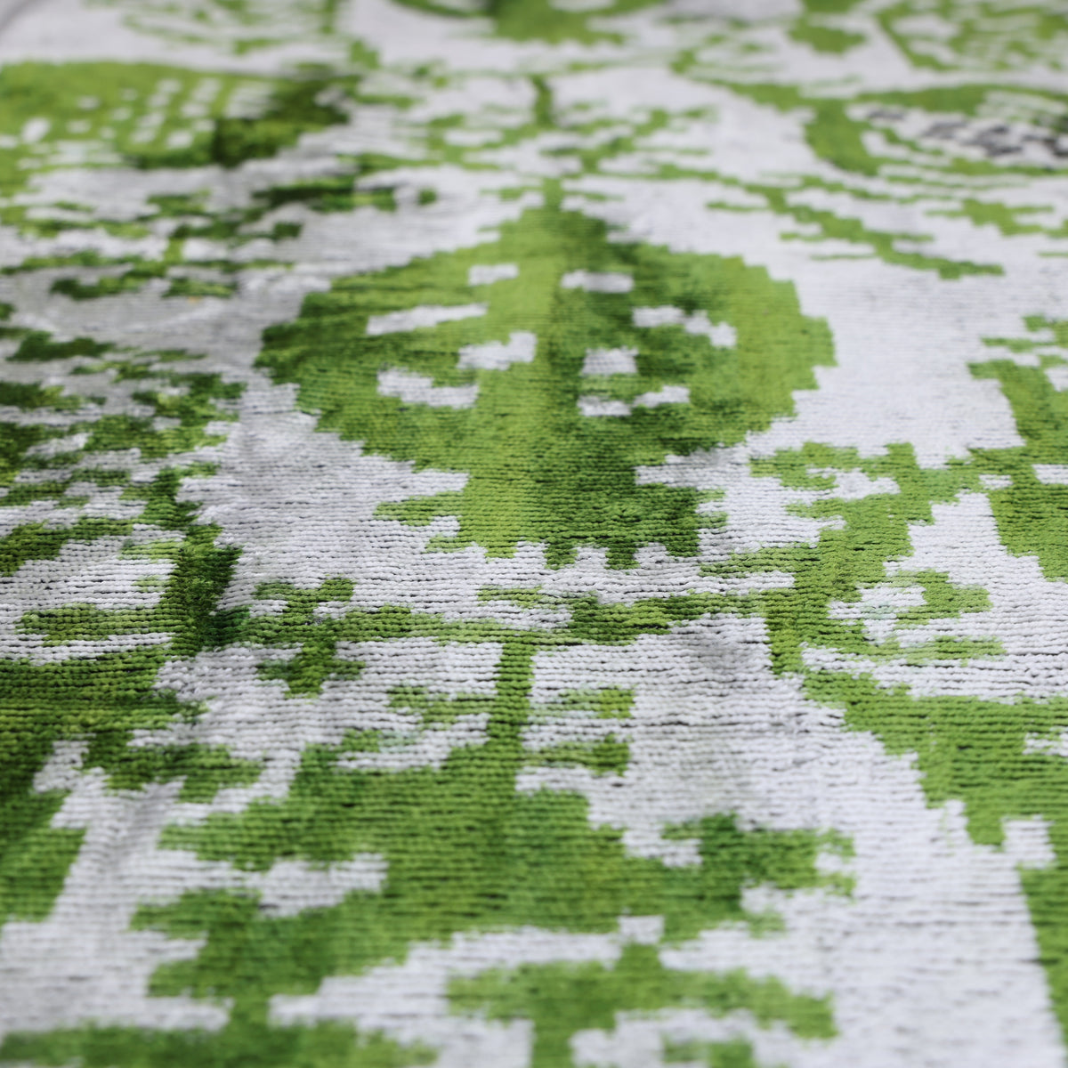 Raking light reveals the pomegranate ikat pattern and velvet pile
