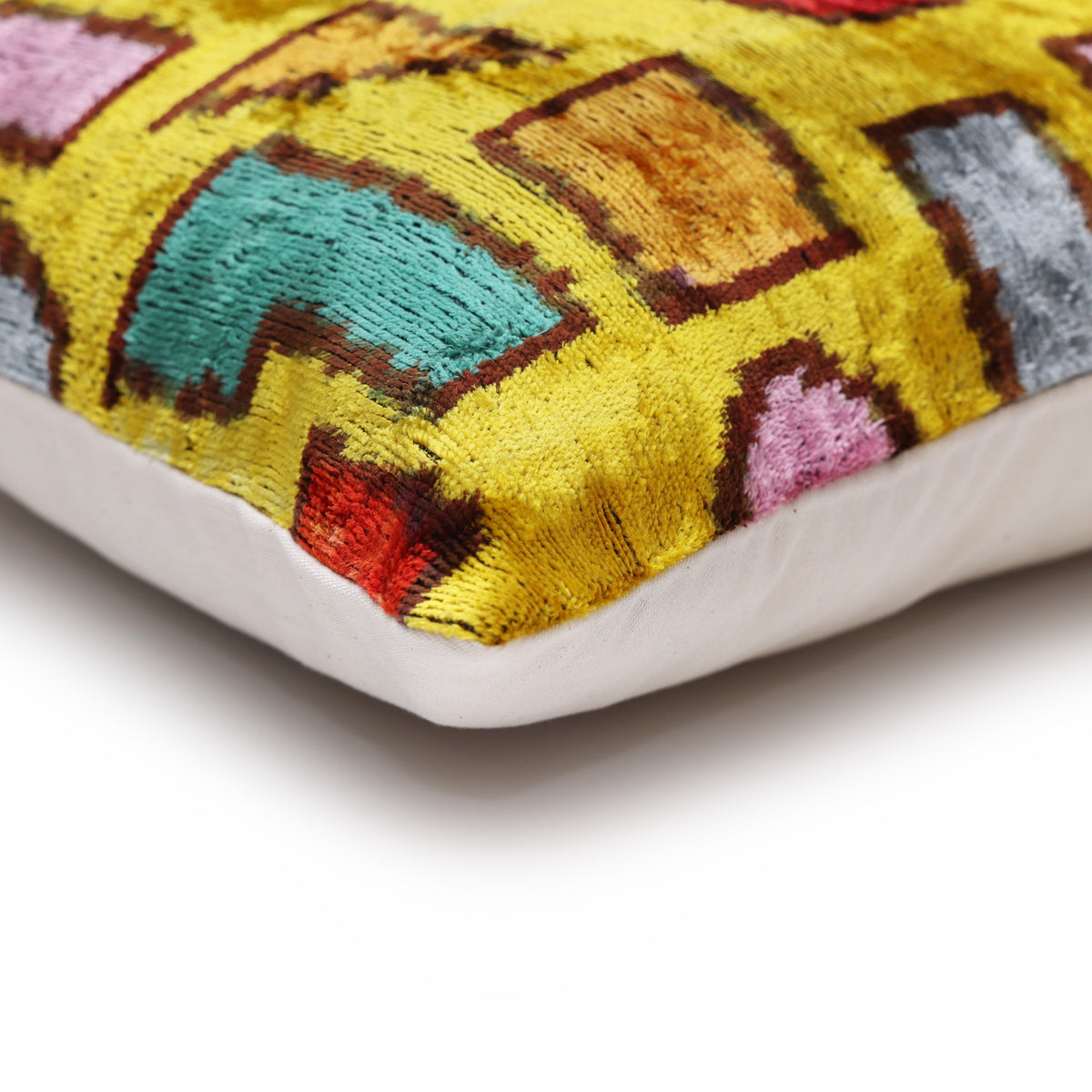 Corner view of mustard geometric lumbar pillow with piped edge and contrast backing