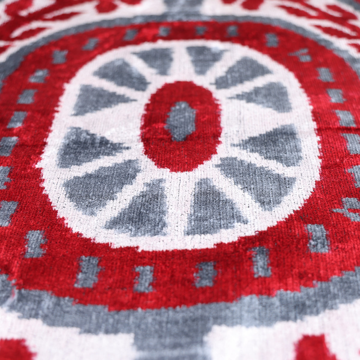 Angled detail of the slate gray and crimson red central rosette motif