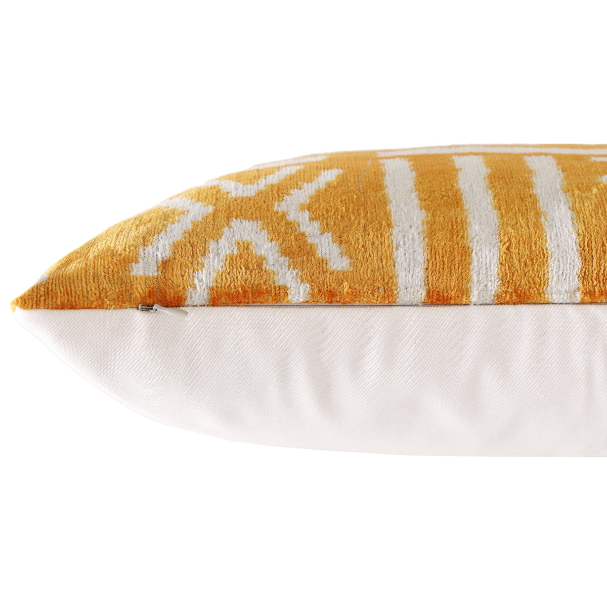 Detail of hidden zipper closure along the seam of a marigold and ivory geometric pillow