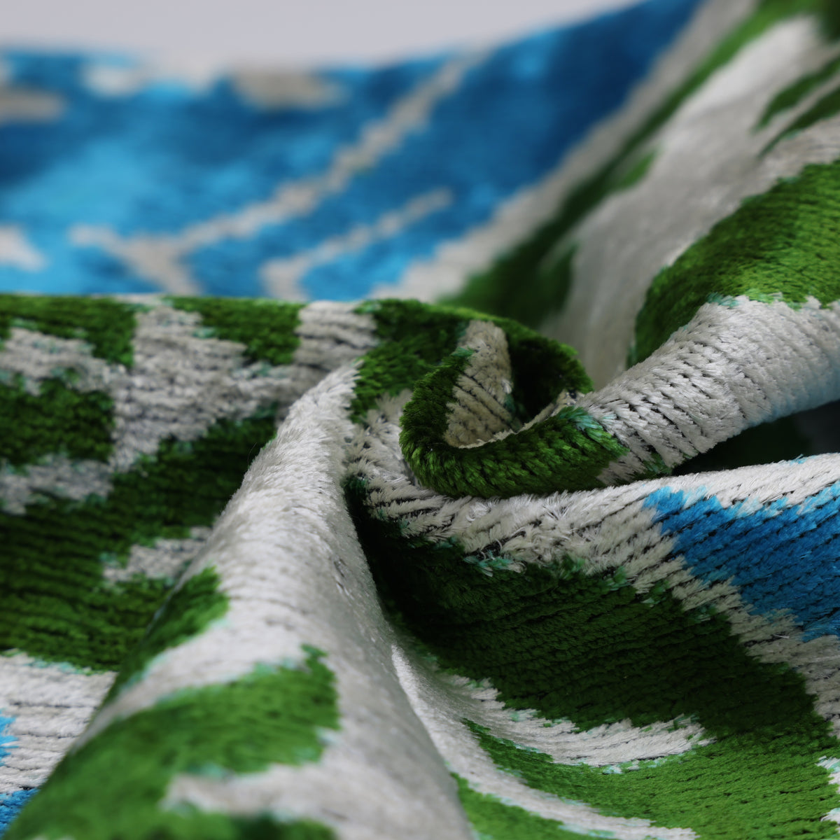 Angled close-up of cerulean teal silk velvet with visible cut pile texture