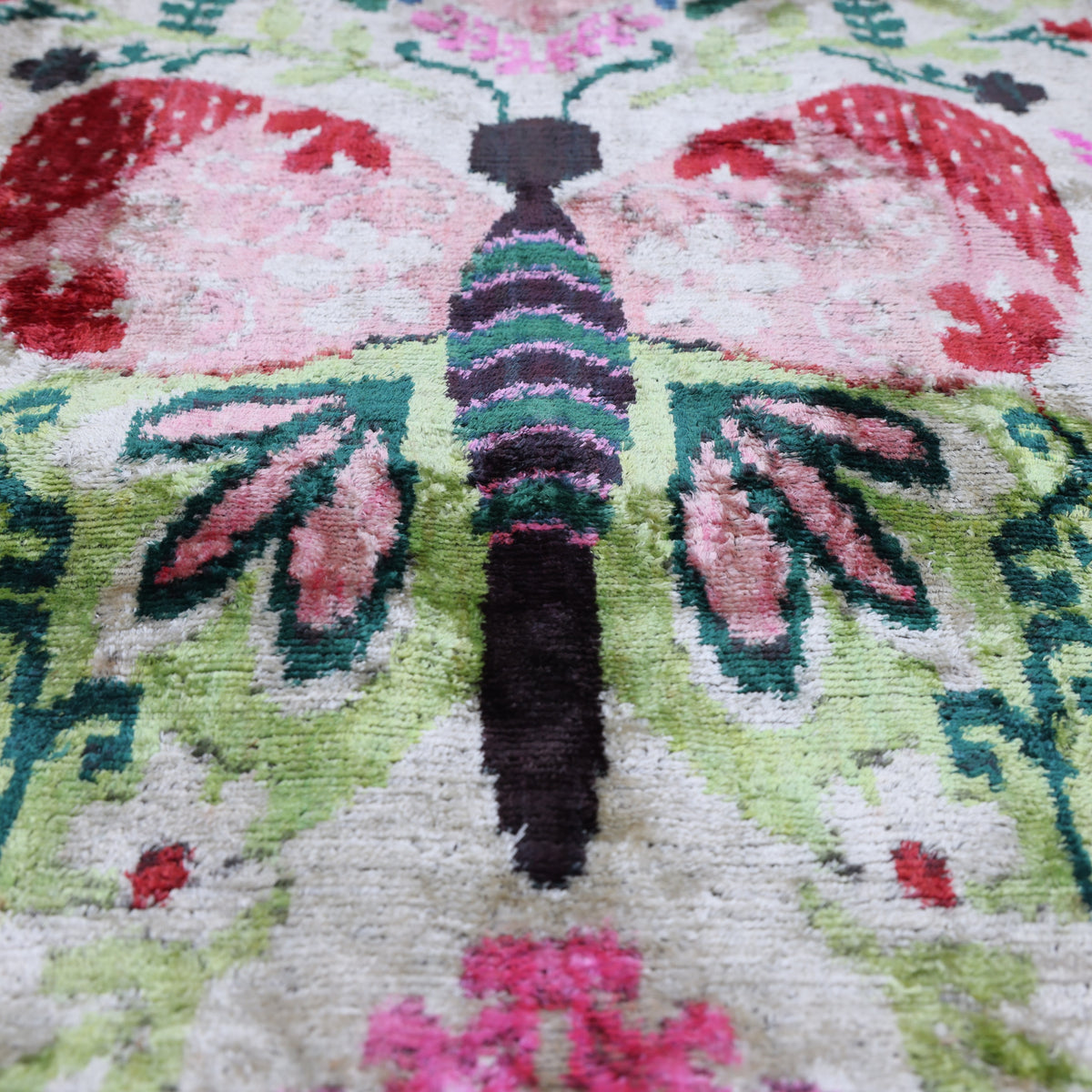Central butterfly detail with blush pink wings, crimson red accents and botanical foliage