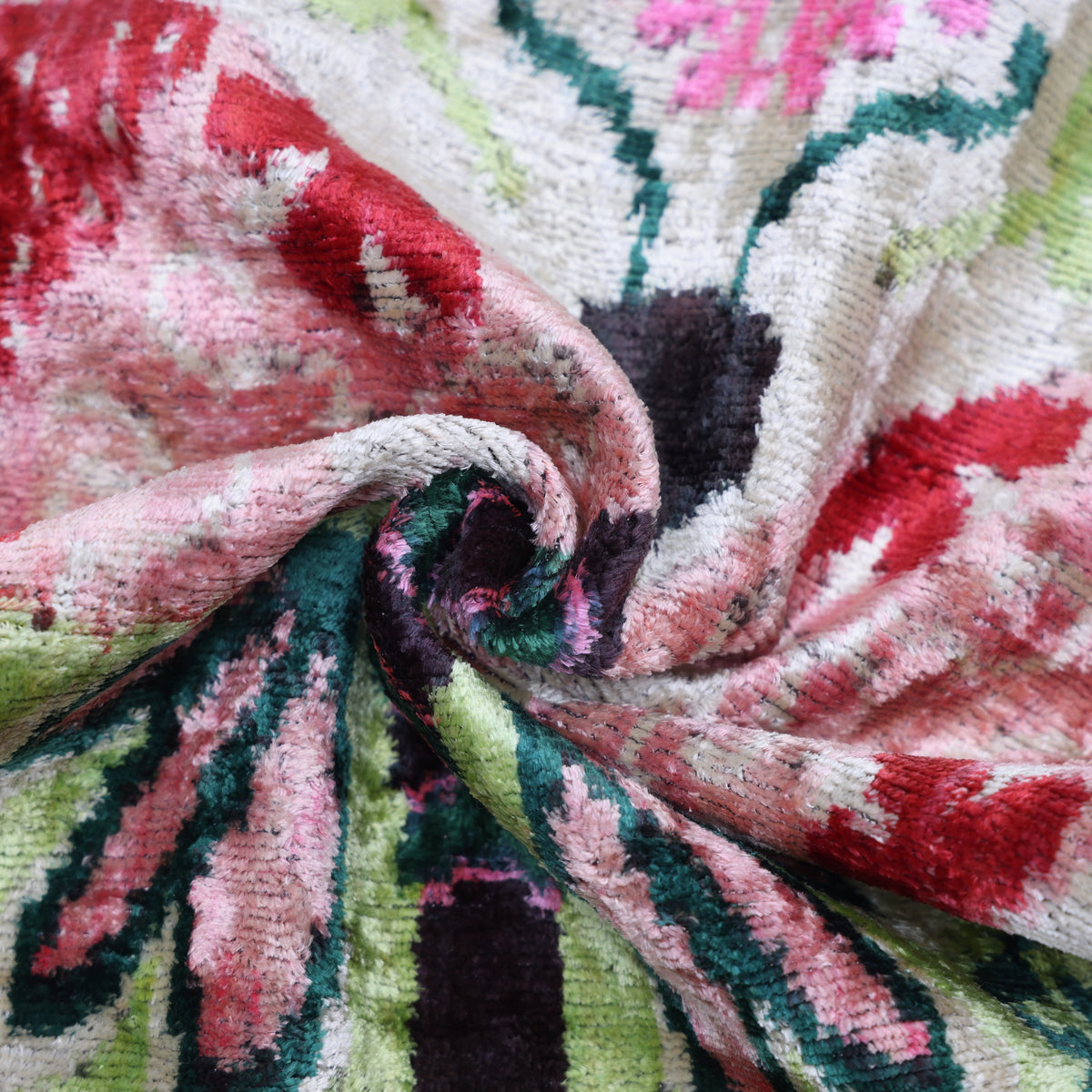 Close-up of silk velvet pile showing blush pink, crimson red, lime green and forest green hues