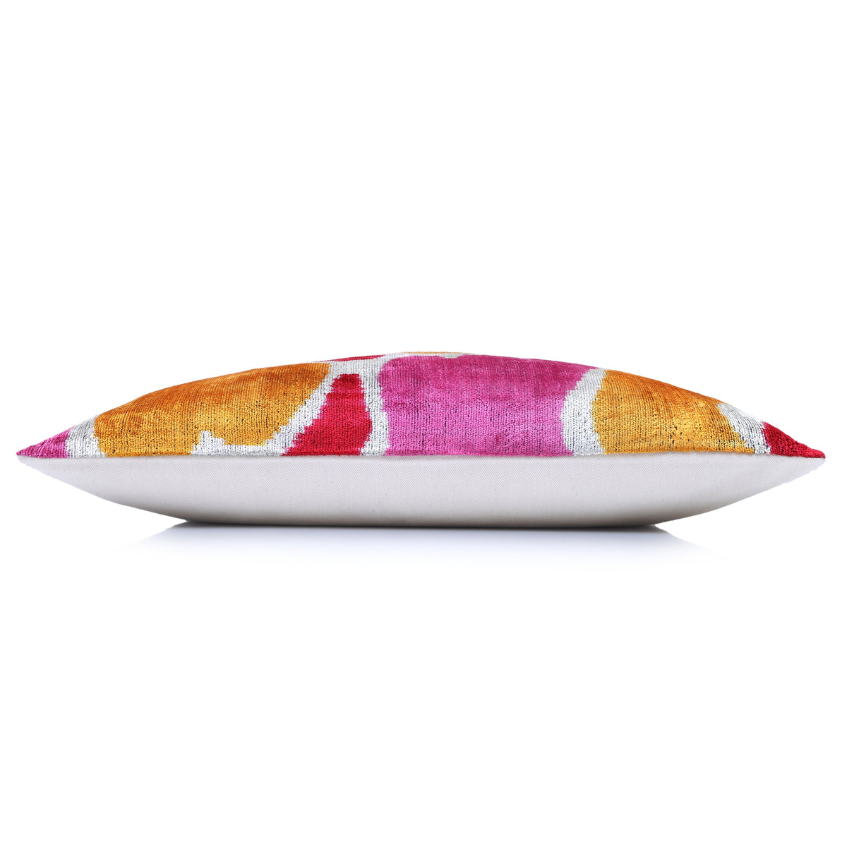 Side edge of abstract ikat lumbar pillow showing marigold velvet front and linen backing