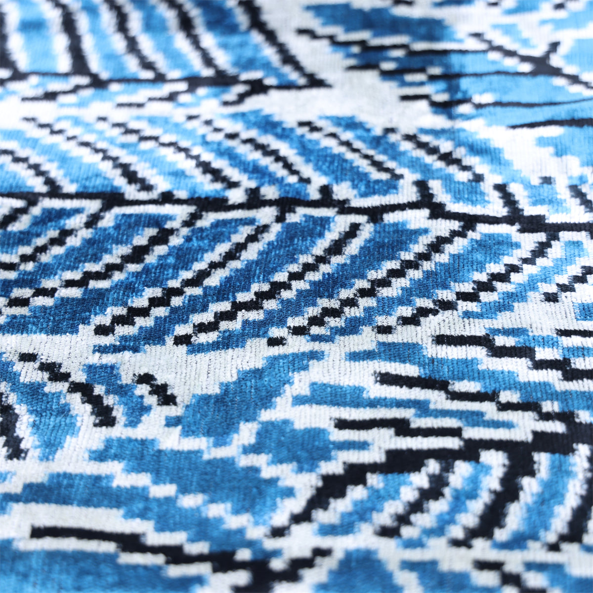 Angled close-up of blue and white herringbone feather ikat pattern