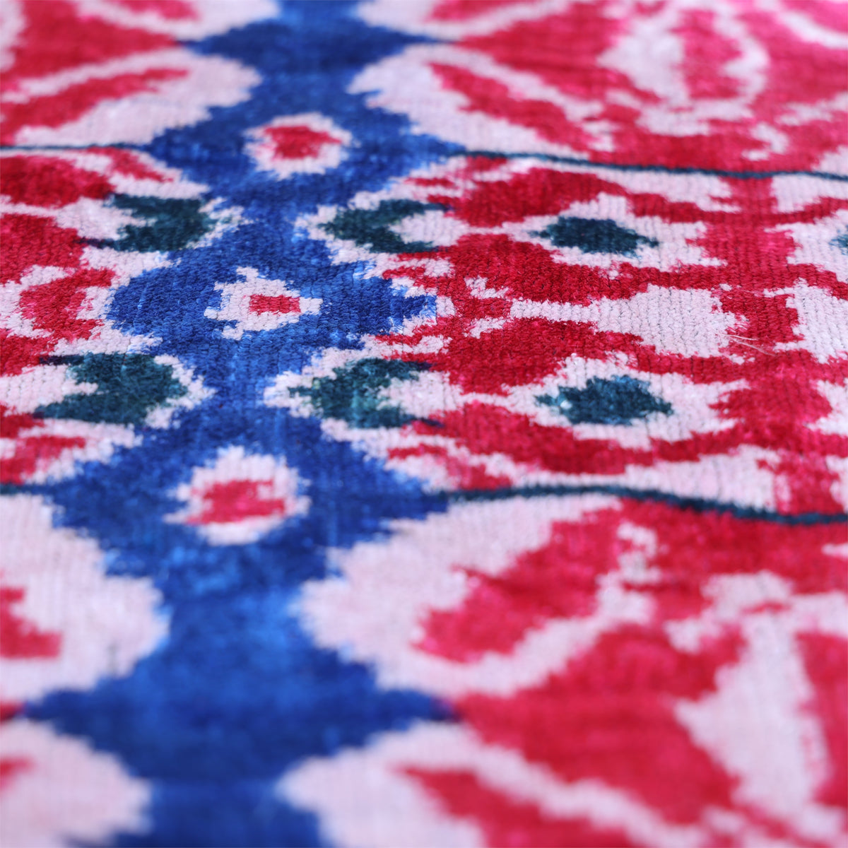 Low-angle view of cobalt blue and deep teal ikat details in velvet pile