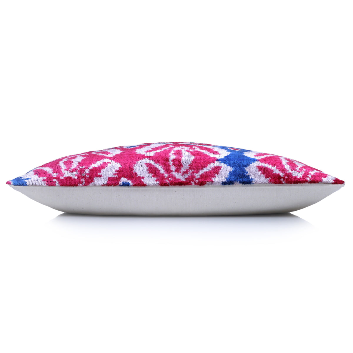 Side edge of ikat lumbar pillow showing velvet profile and solid backing