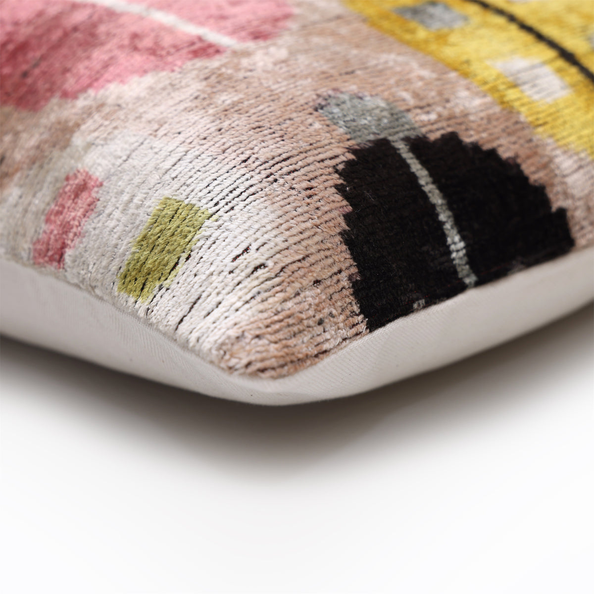 Pillow corner showing silk velvet face, pale blush beige medallions and woven linen back