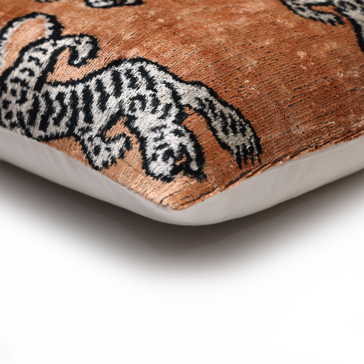 Corner profile of camel tiger lumbar pillow showing seam and plain backing