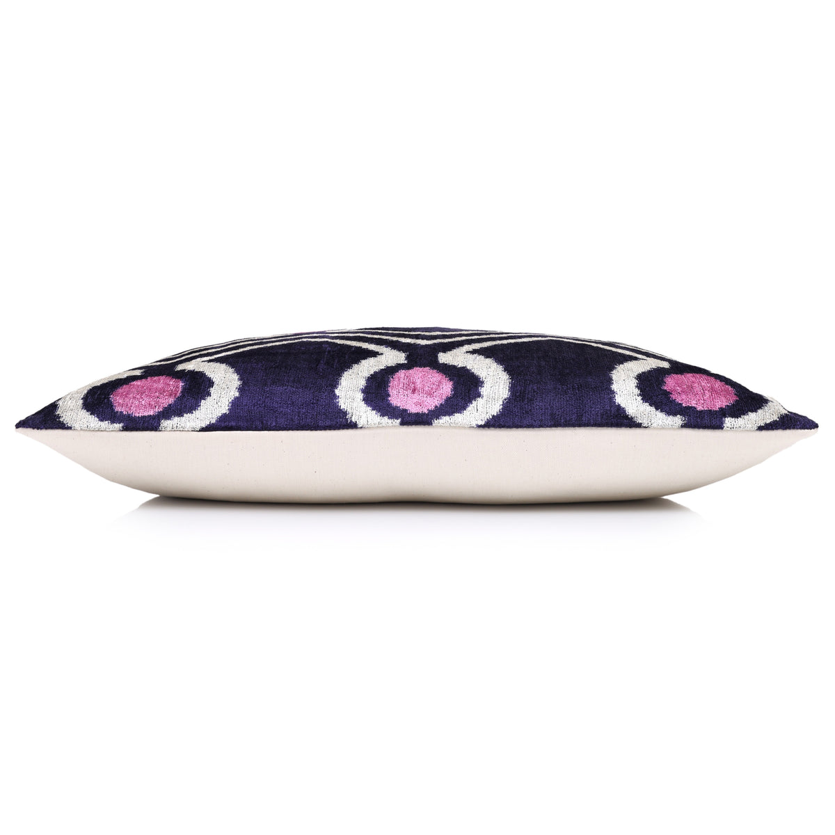 Profile edge of a deep indigo purple geometric lumbar pillow with white backing
