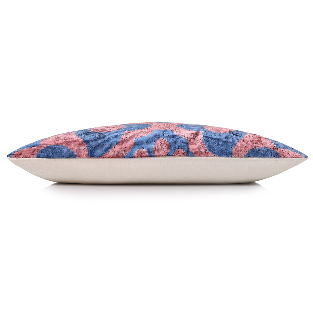 Side profile of a slate blue and dusty rose pink lumbar pillow with linen backing