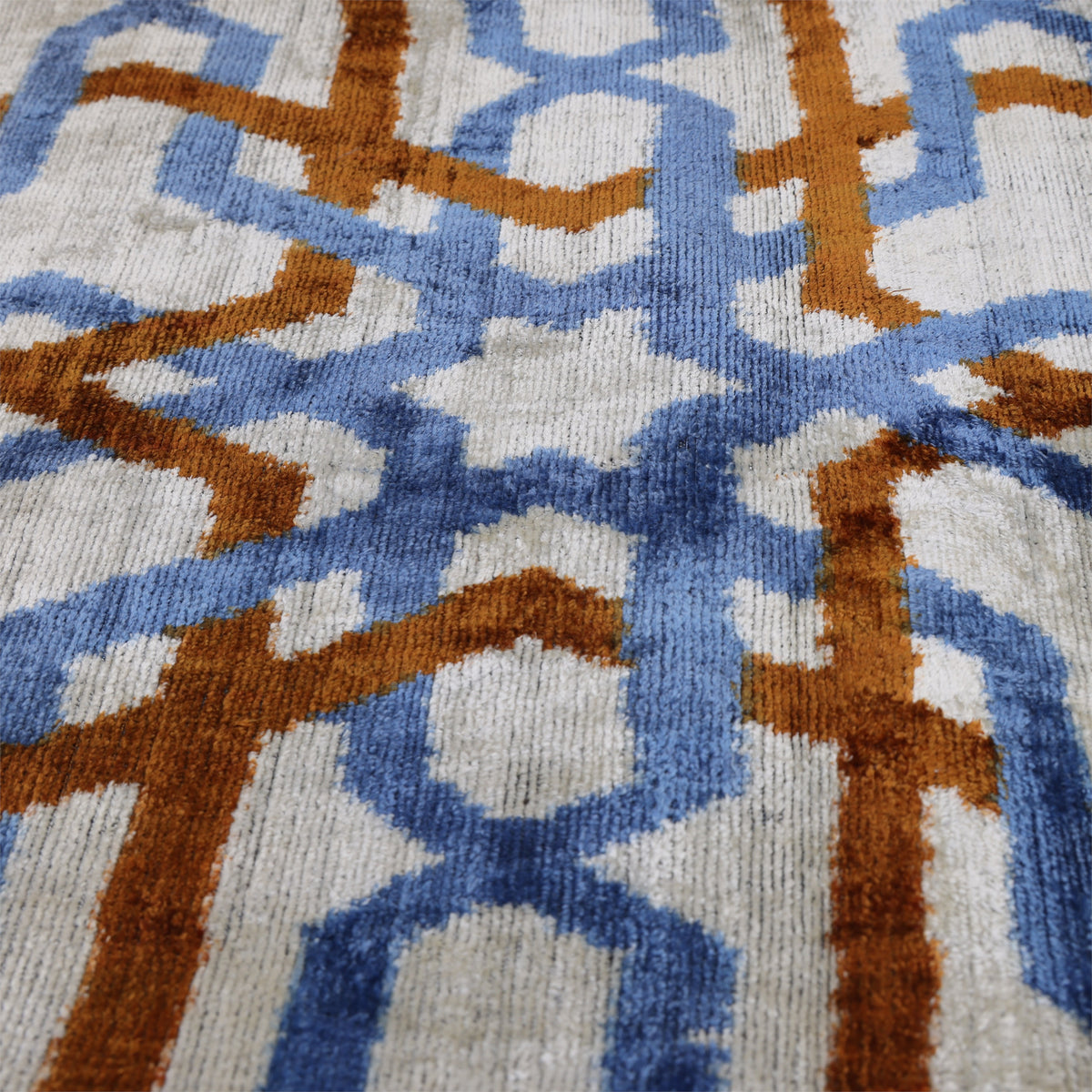 Overhead detail of the cornflower blue and cognac rust geometric ikat motif