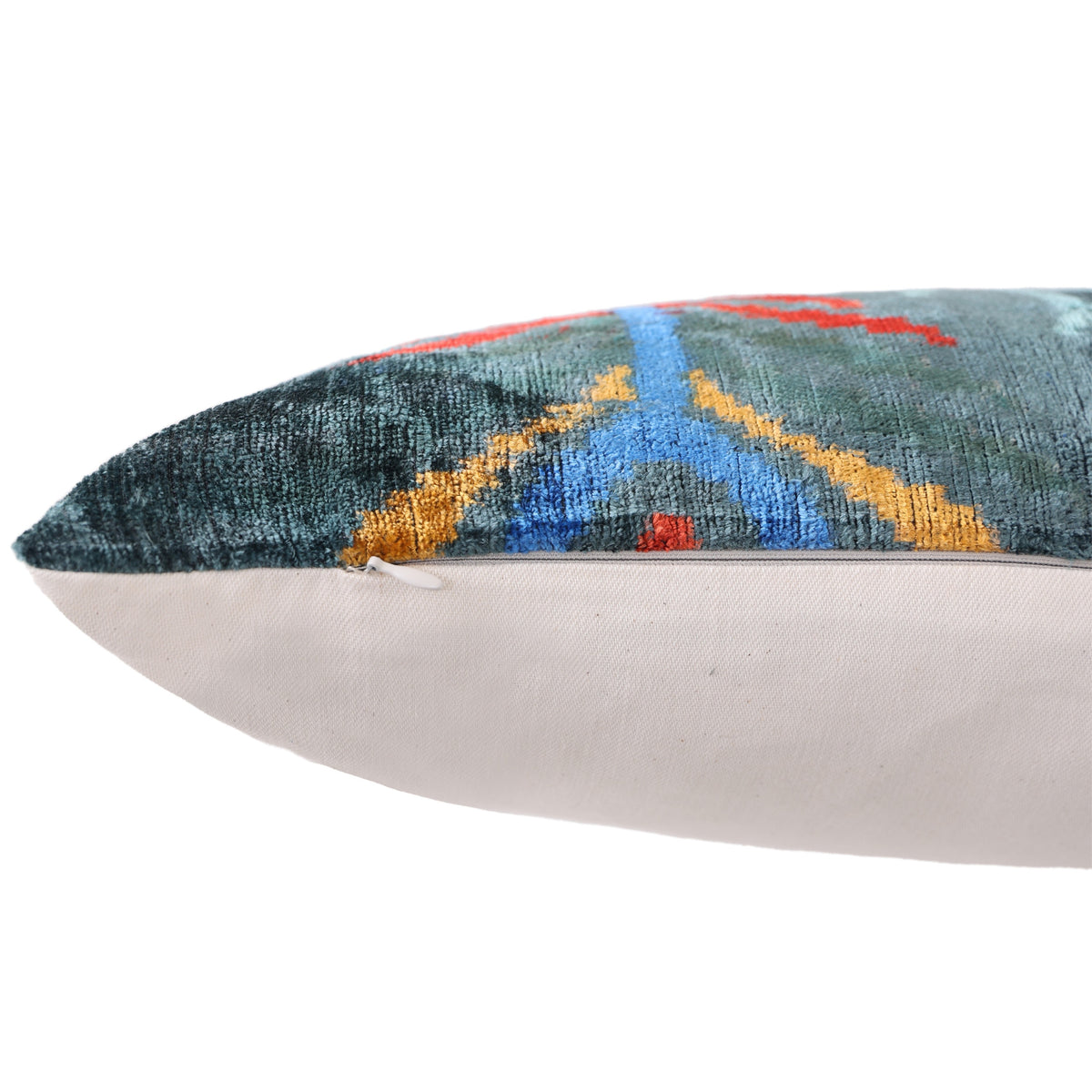 Side edge showing hidden zipper and neutral linen backing on ikat lumbar pillow