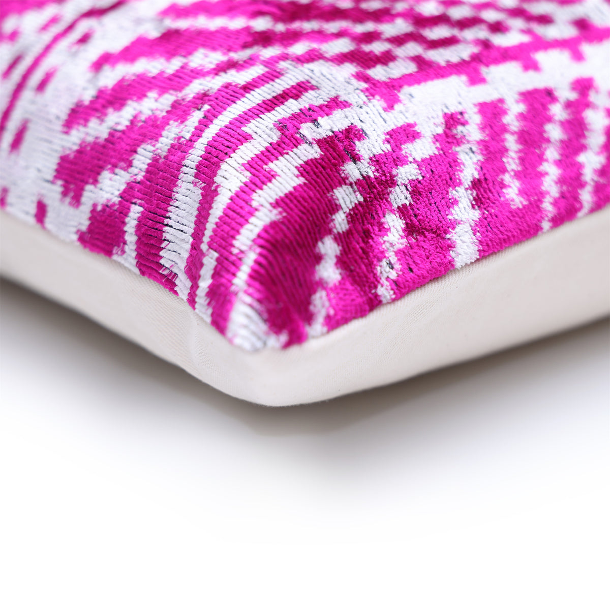 Close-up corner of magenta pink and crisp white pillow showing seam and fabric edge