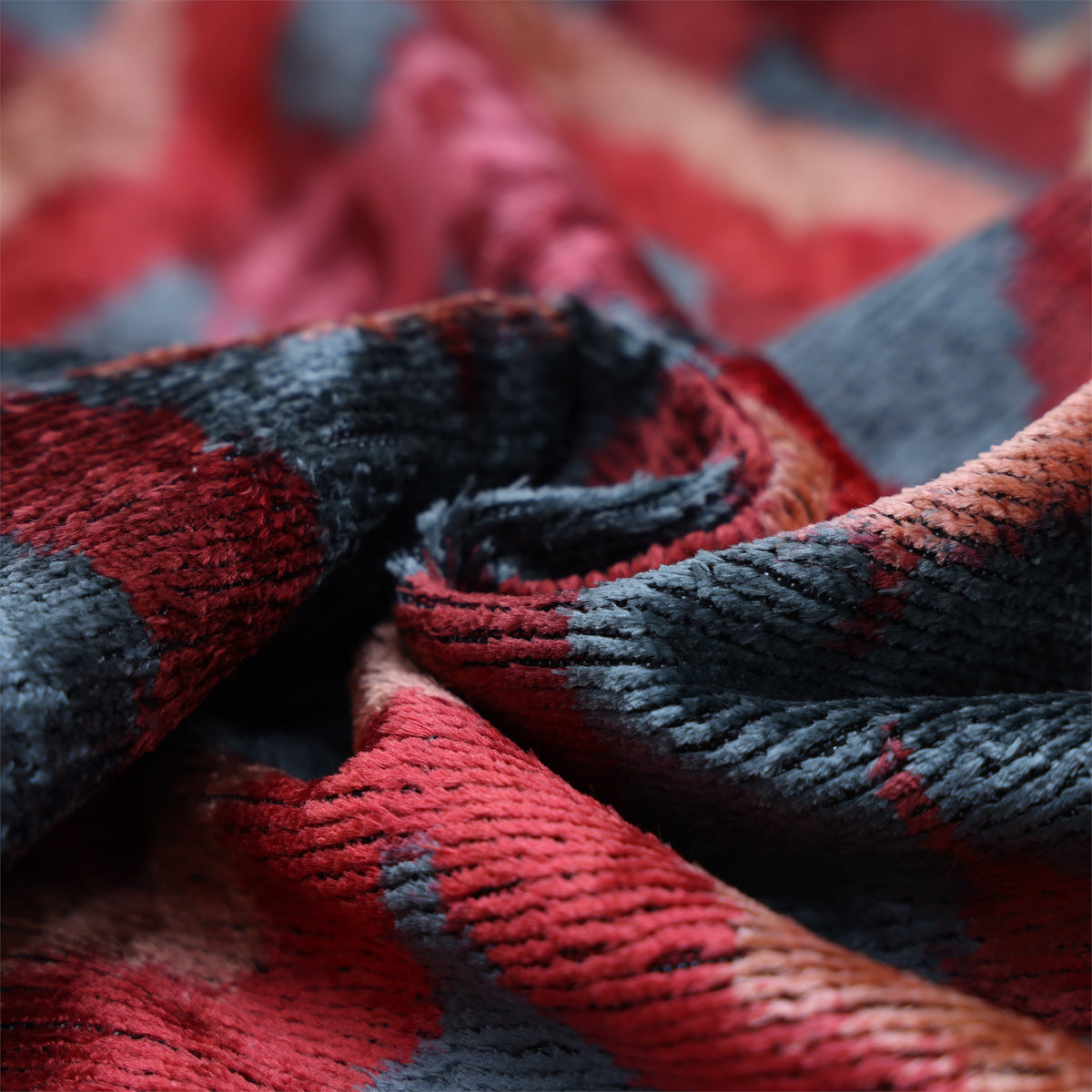 Side close-up showing folded crimson red velvet, cut pile and changing sheen