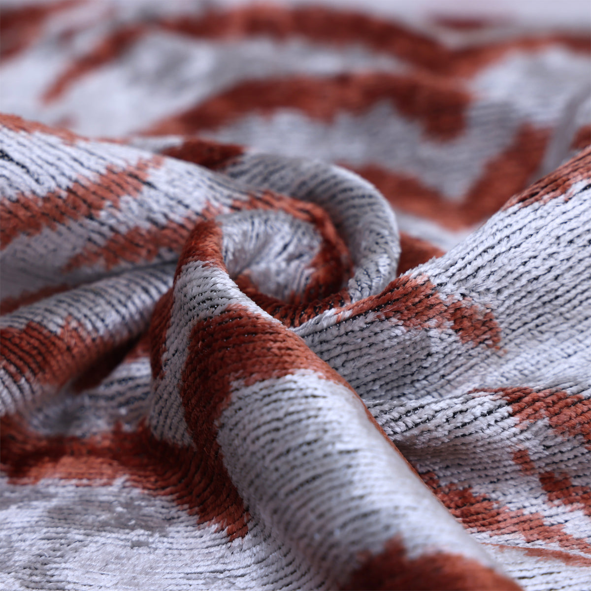 Folded silver gray and rust silk velvet showing sheen and ribbed texture