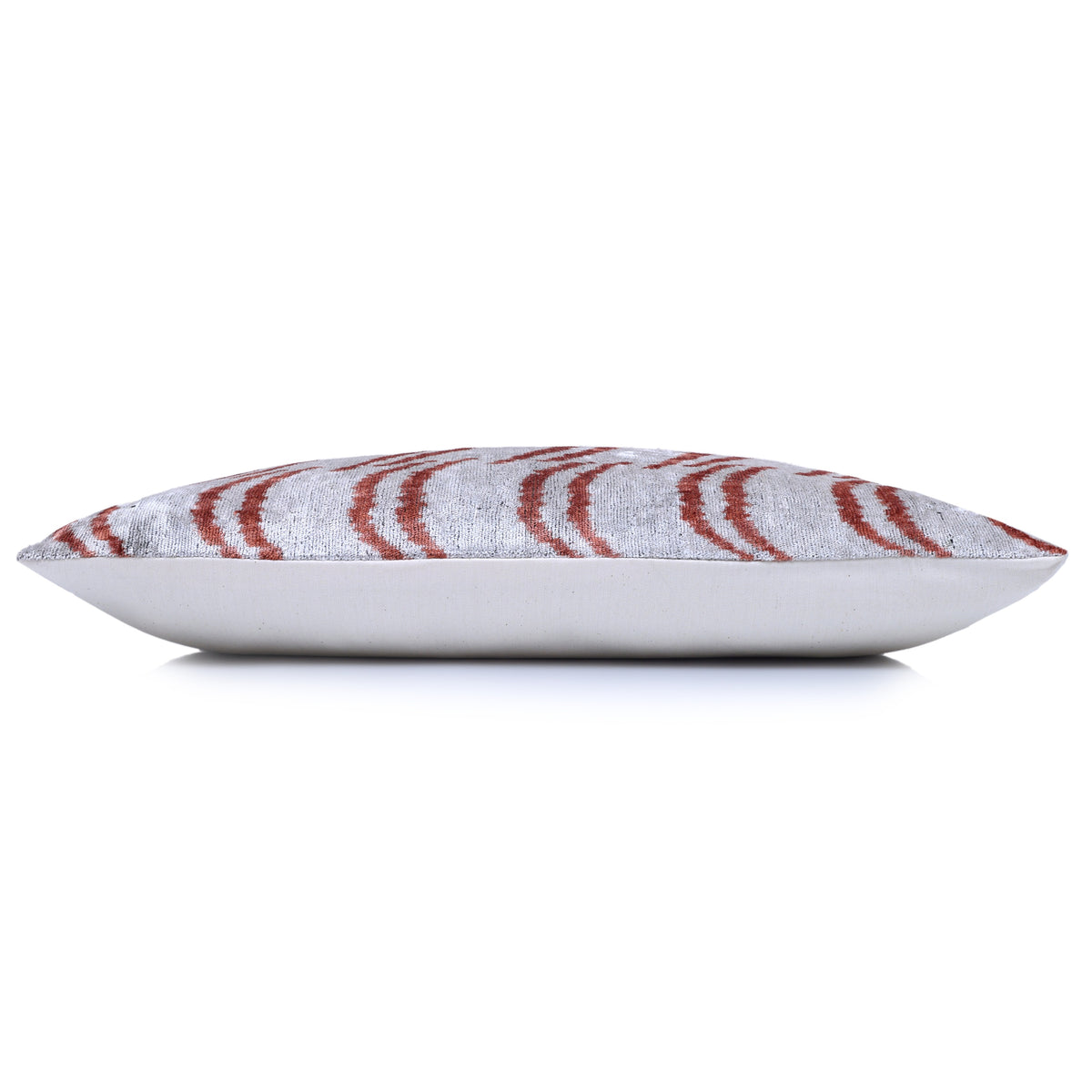 Side profile of silver gray and rust lumbar pillow showing depth and backing