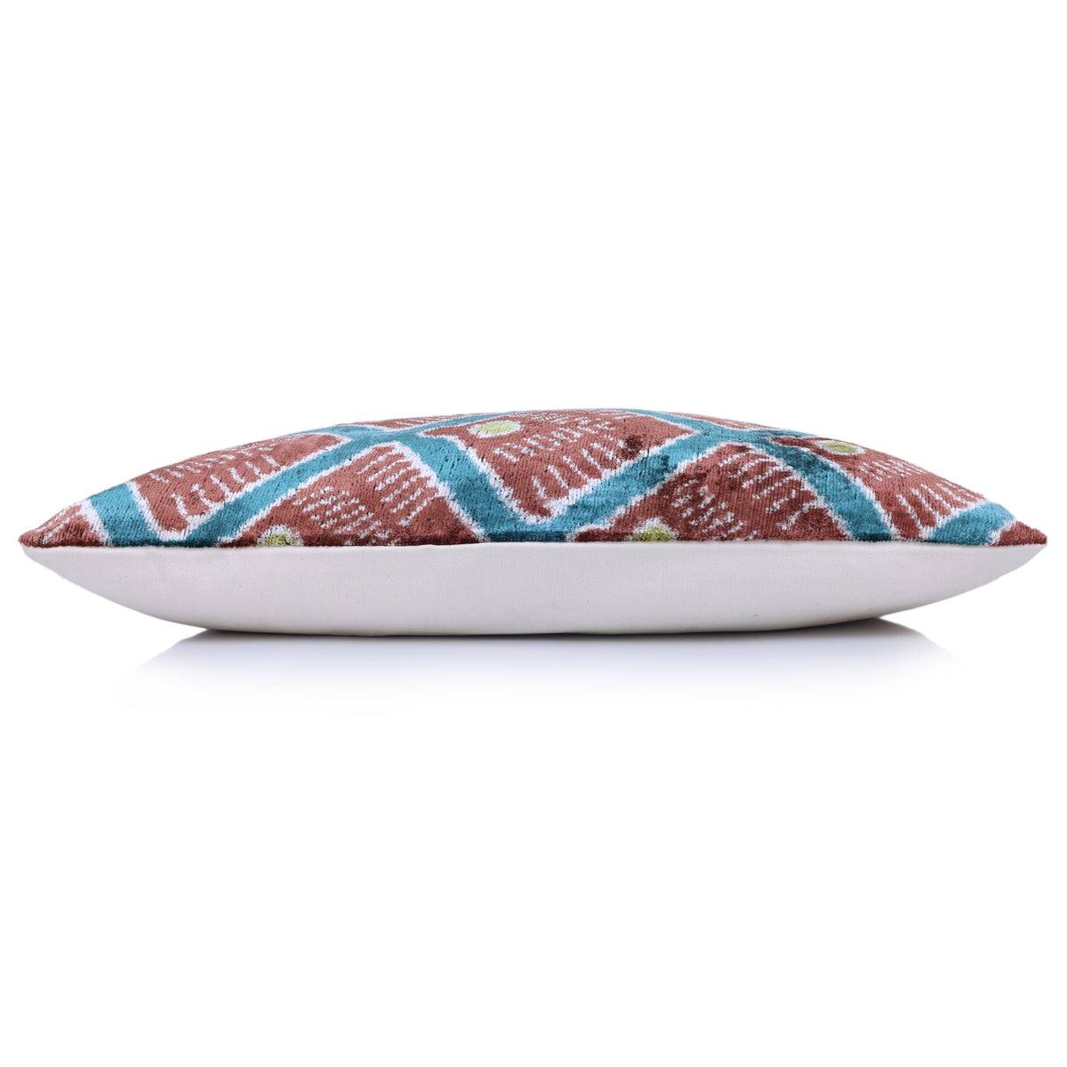Bottom edge of terracotta rust and teal lumbar pillow with soft white fabric backing