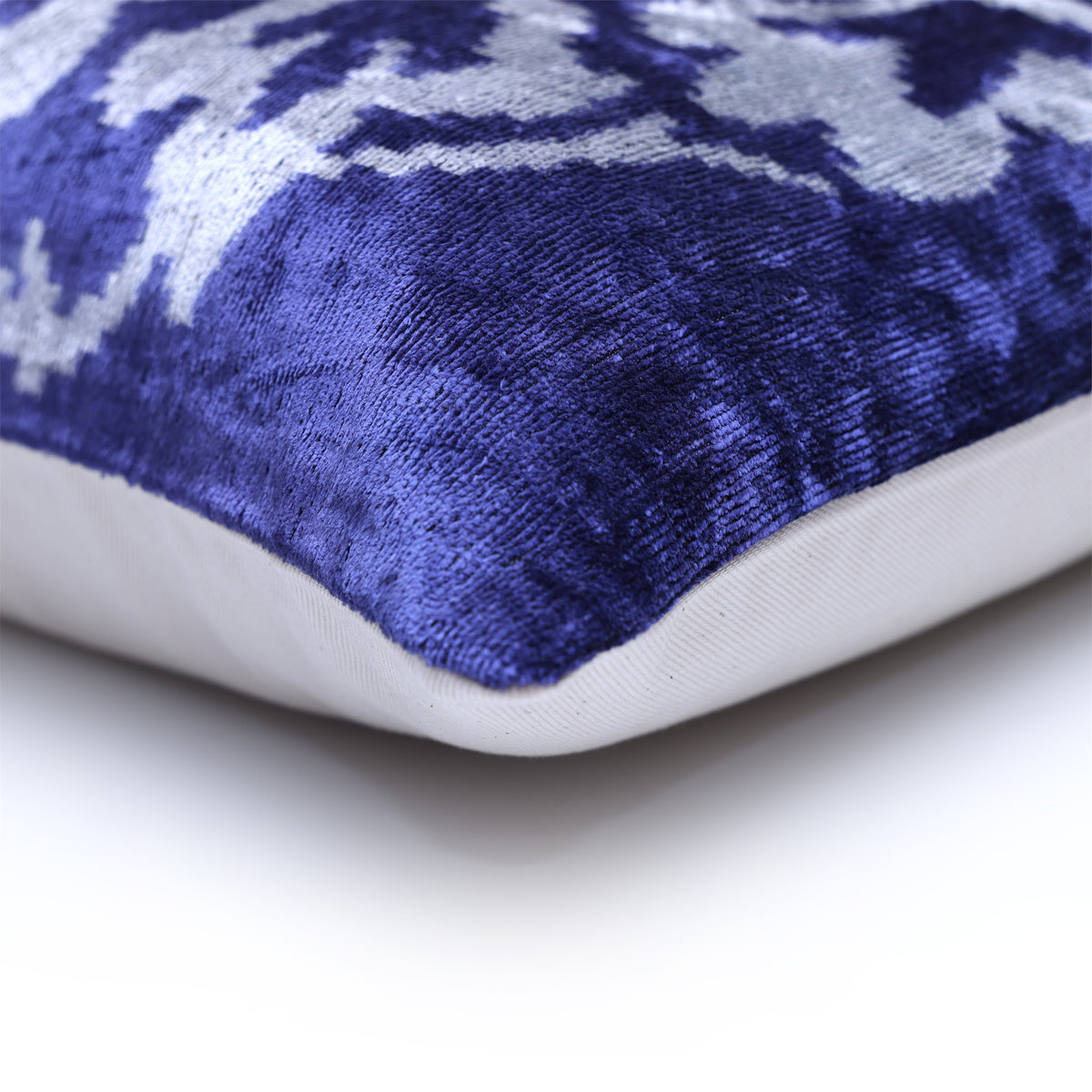 Corner view of cobalt blue patterned velvet face with solid backing