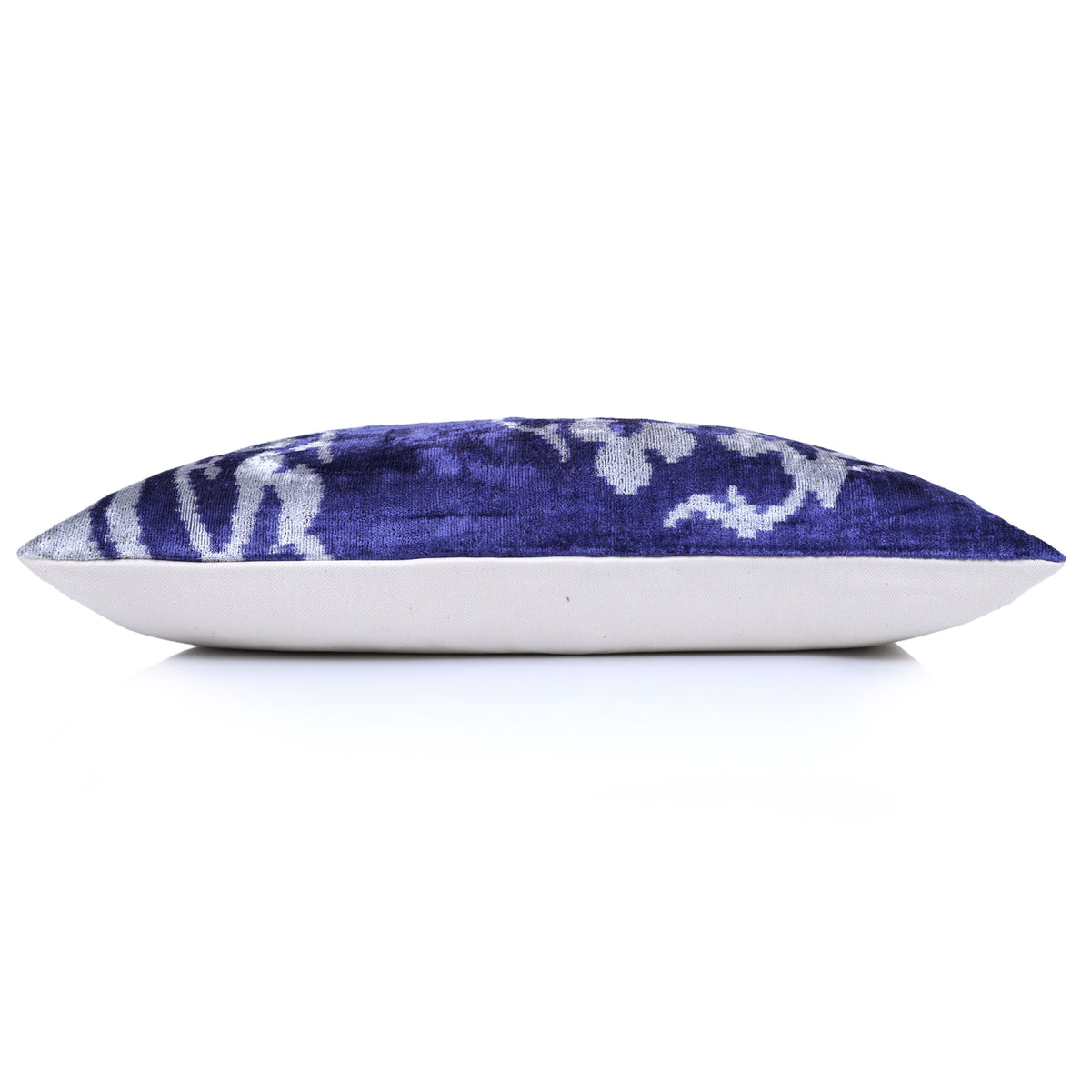 Side profile showing the lumbar pillow's cobalt blue velvet edge