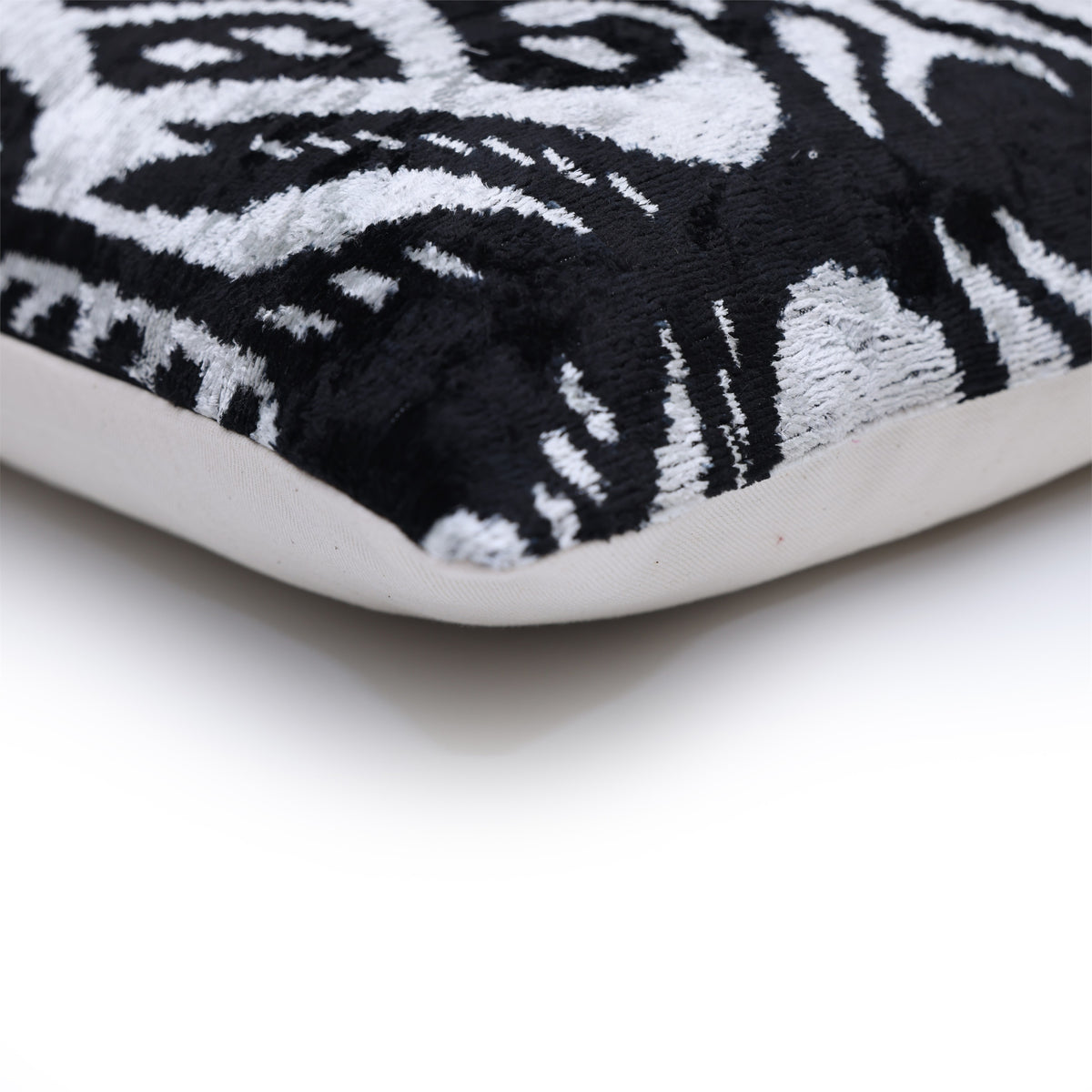 Corner detail of silvery white and jet black velvet edge and seam